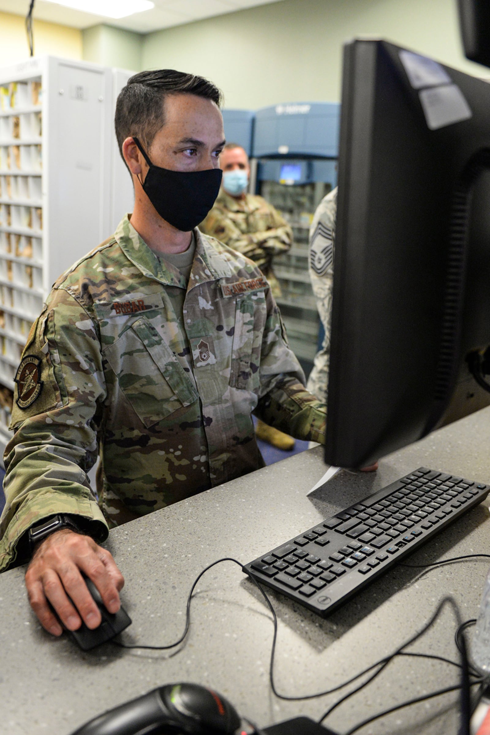 Chief Master Sgt. Gary Bubar, 88th Security Forces Squadron manager, enters a patient’s information into the computer while volunteering at the Kittyhawk Pharmacy Aug. 7. (U.S. Air Force photo/Wesley Farnsworth)