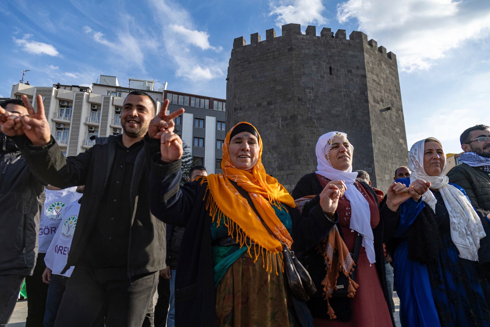 Kurdish people dance as they gather to watch live on a tv screen a Pro-Kurdish Peoples' Equality and Democracy Party, or DEM, delegation members releasing an statement from the jailed leader of the rebel Kurdistan Workers' Party, or PKK, Abdullah Ocalan, in Diyarbakir, Turkey, Thursday, Feb. 27, 2025. (AP Photo/Metin Yoksu)