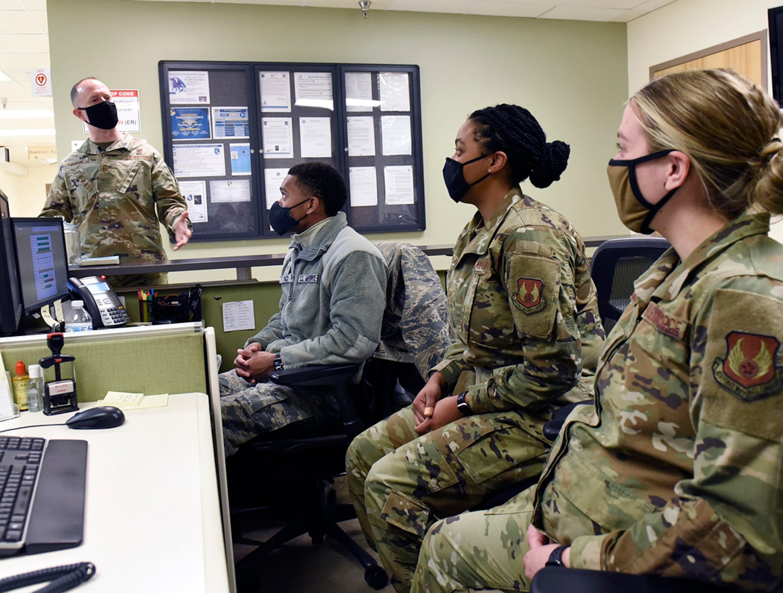 Air Force Senior Master Sgt. Bruce D. Haskin, left, a superintendent for the 88th Air Base Wing Medical Support Squadron, speaks with Airman 1st Class Kujwaun Mack, Staff Sgt. Dundrashae Plater, and Airman 1st Class Amy Hebenstreich, logisticians for the 88th MDSS at Wright-Patterson Air Force Base Medical Center, Ohio on Feb. 8, 2021. Haskin, a Purple Heart recipient, sustained a traumatic brain injury and severe tinnitus when a vehicle-borne improvised explosive device was detonated during an attack at Bagram Air Base, Afghanistan, on Dec. 11, 2019. (U.S. Air Force photo by Ty Greenlees)