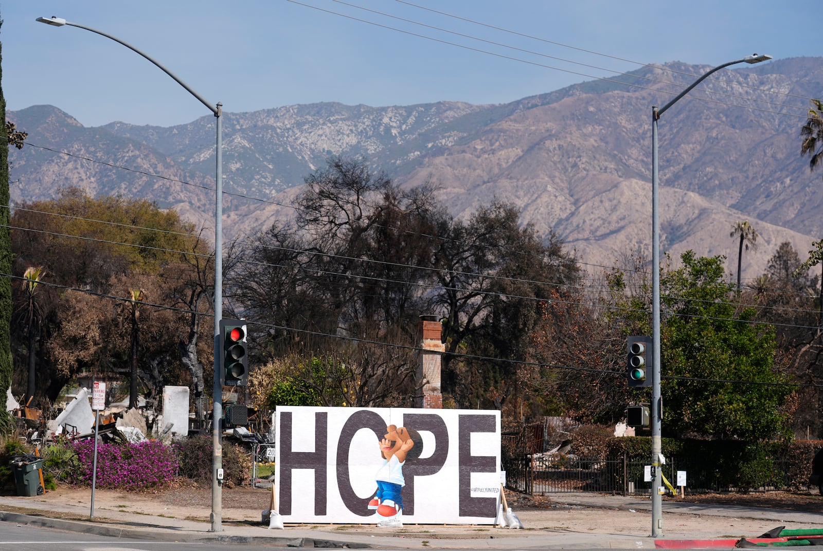 A mural sits in front of a burned property on Woodbury Avenue a month after the Eaton Fire, Monday, Feb. 17, 2025, in Altadena, Calif. (AP Photo/Chris Pizzello)