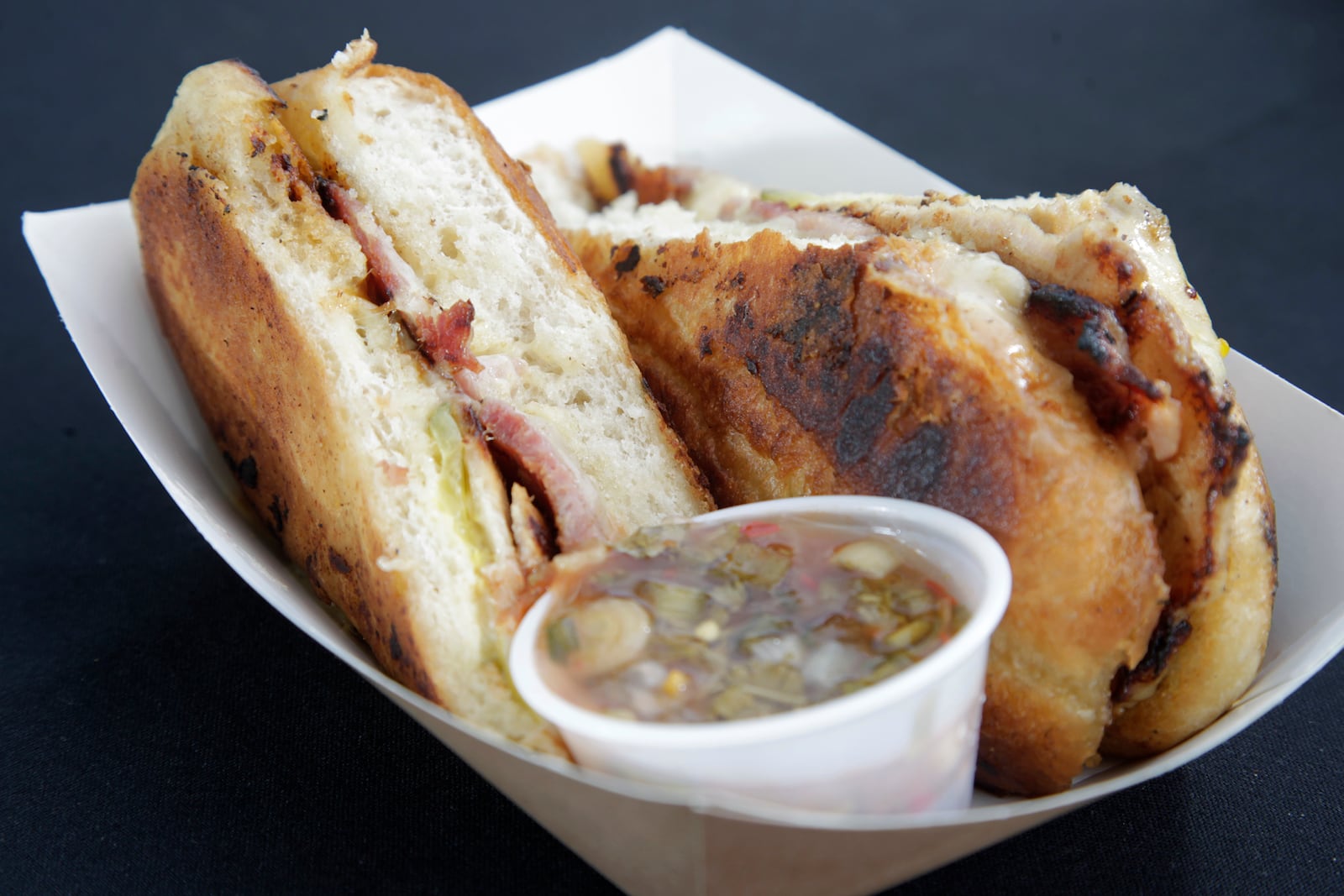 El Meson's Cuban Sandwich is the best seller on its fleet of food trucks. The sandwich is made with ham, pork, cheese, pickles, mayo and aji sauce, El Meson's homemade salsa. LISA POWELL / STAFF