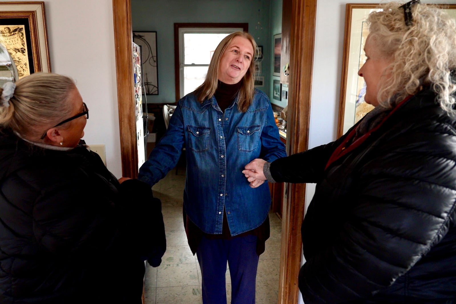 Barbara Teed thanks Jan Orcutt and Wendy Vossen for delivering food for herself and her 30-year-old son Ryan, who has Down syndrome, on Wednesday, Jan. 29, 2025, in Bloomington, Minn. (AP photo/Mark Vancleave)