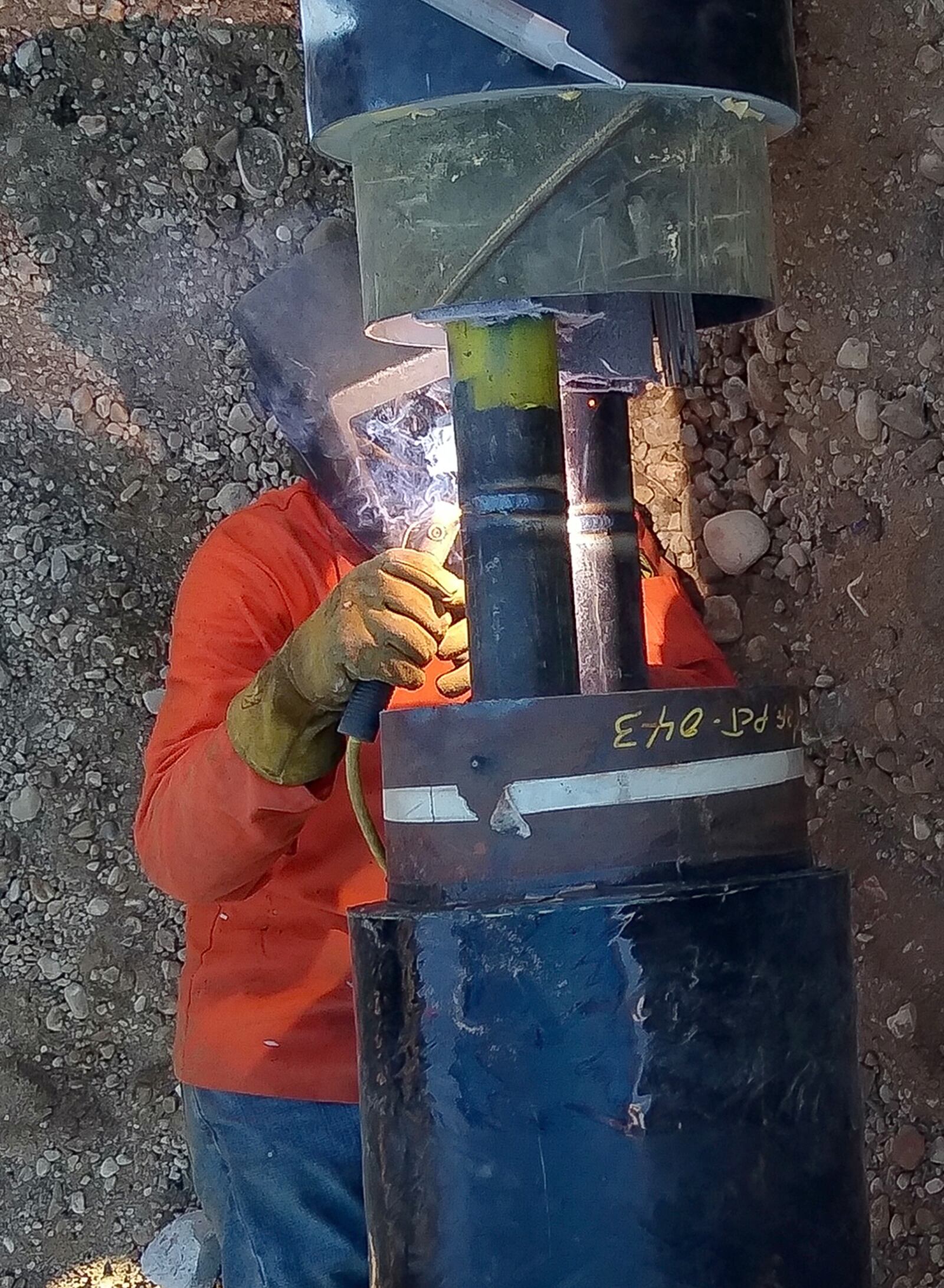 Behind the glare of an arc-welding rod, Bill Leonard, a contractor from DeBra-Kuempel, welds sections of high-temperature water-transmission pipe together June 29 in the Kittyhawk area of Wright-Patterson Air Force Base. The work is part of an effort to modernize the decades-old hot water delivery system used for heating several buildings. U.S. AIR FORCE PHOTO/WILL HUNTINGTON