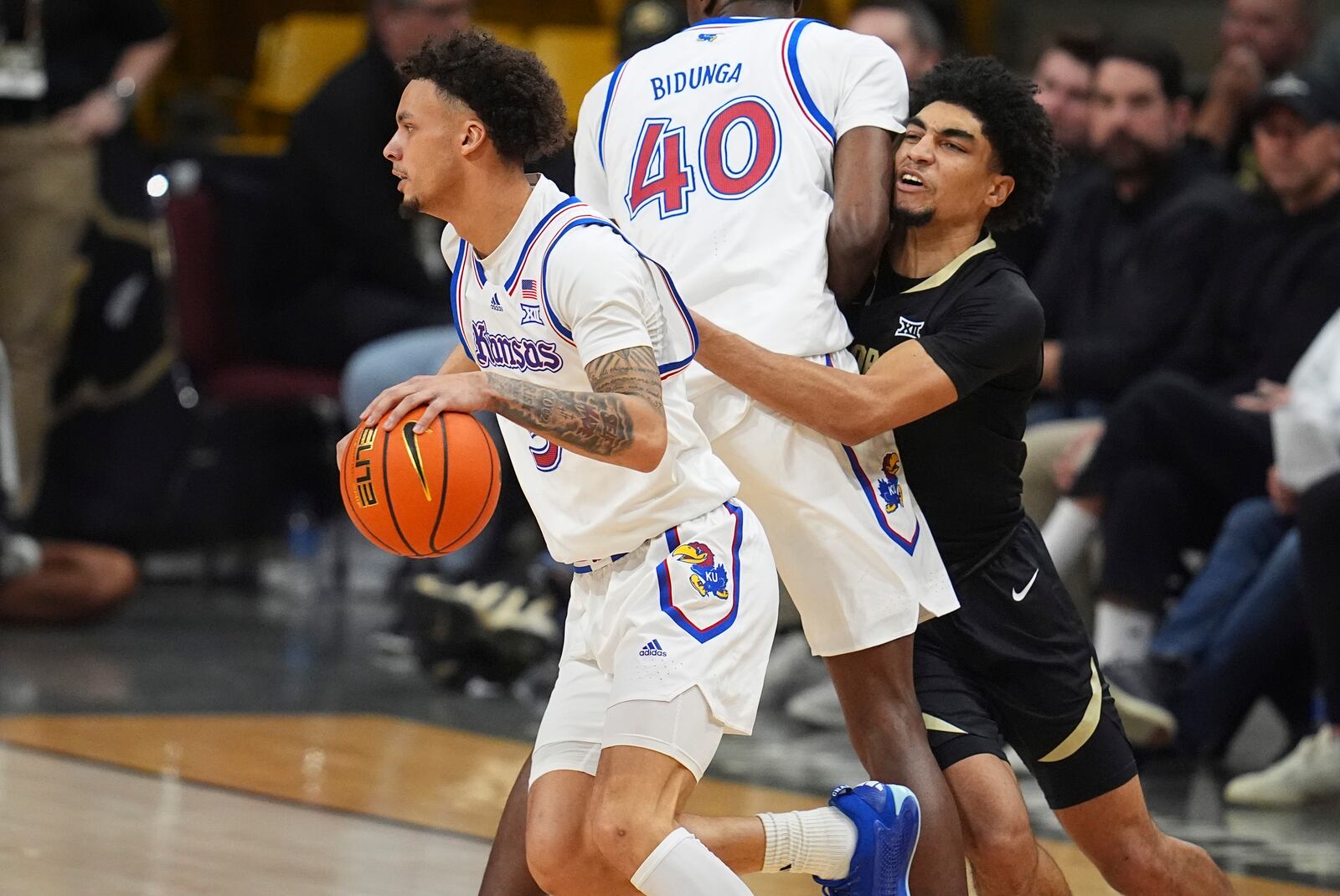 Kansas guard Zeke Mayo, left, drives past forward Flory Bidunga (40) as he blocks Colorado guard RJ Smith in the second half of an NCAA college basketball game Monday, Feb. 24, 2025, in Boulder, Colo. (AP Photo/David Zalubowski)