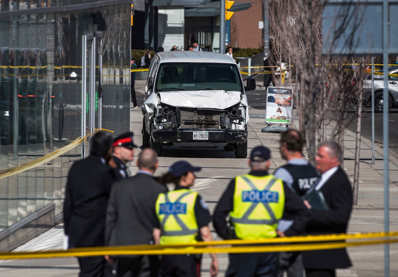 FILE - In this April 23, 2018, file photo, police stand near a damaged van after a van mounted a sidewalk crashing into pedestrians in Toronto. (Aaron Vincent Elkaim/The Canadian Press via AP, File)