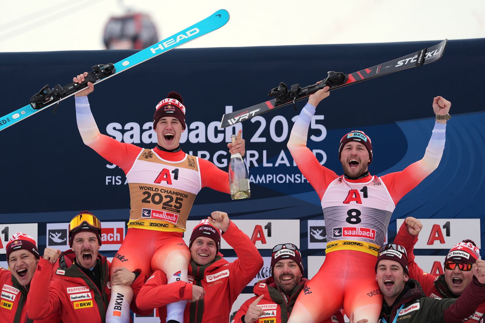 Gold medalist in a men's downhill race Switzerland's Franjo von Allmen, left, and bronze medalist Switzerland's Alexis Monney, celebrate with the team, at the Alpine Ski World Championships, in Saalbach-Hinterglemm, Austria, Sunday, Feb. 9, 2025. (AP Photo/Giovanni Auletta)