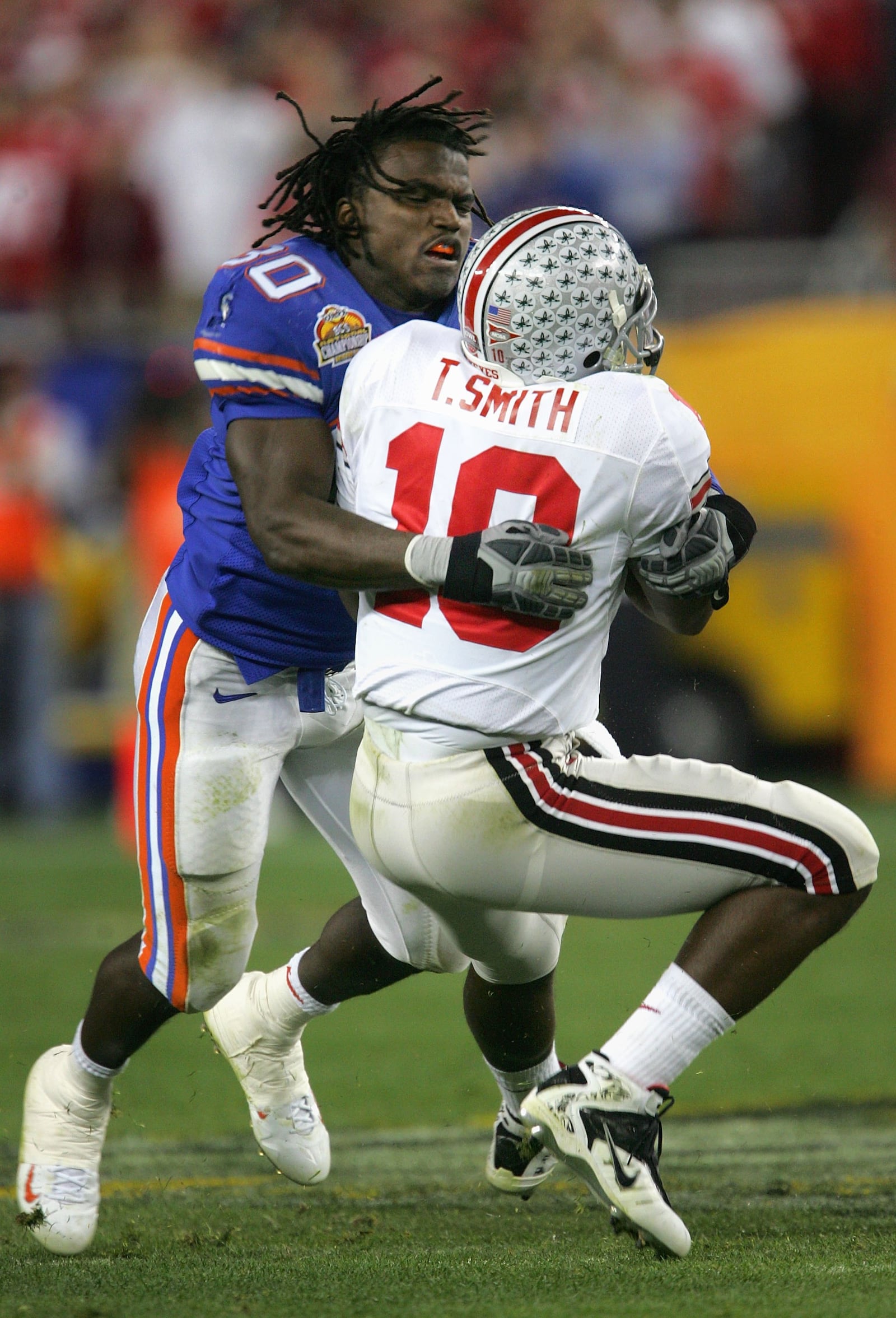 GLENDALE, AZ - JANUARY 08:  Linebacker Earl Everett #30 of the Florida Gators tackles Troy Smith #10 of the Ohio State Buckeyes after losing his helmet during the 2007 Tostitos BCS National Championship Game at the University of Phoenix Stadium on January 8, 2007 in Glendale, Arizona.  (Photo by Stephen Dunn/Getty Images)