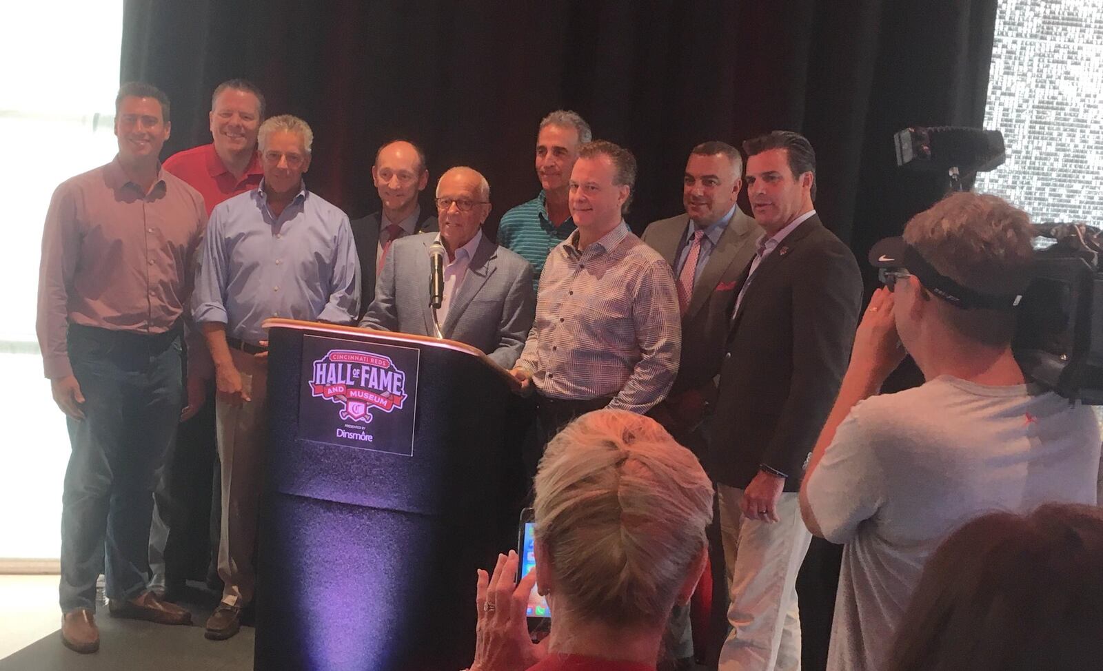 Marty Brennaman poses for a photo with his fellow Reds broadcasters after a press conference at the Reds Hall of Fame and Museum on Friday, Aug. 16, 2019, at Great American Ball Park in Cincinnati.