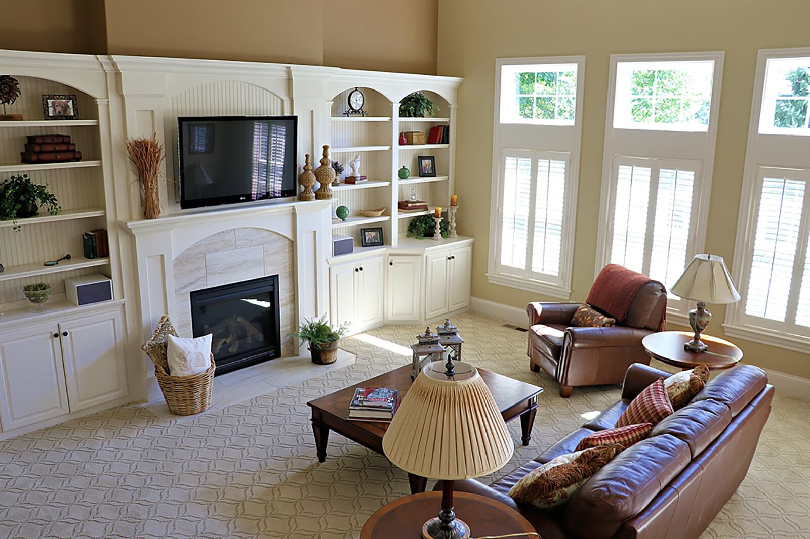 A coffered 16-foot ceiling opens the great room, which has 3 tall windows with box windows above. Built-in cabinetry and bookcases surround a gas fireplace. The fireplace has ceramic surround and a double mantel with media outlets. CONTRIBUTED PHOTO BY KATHY TYLER