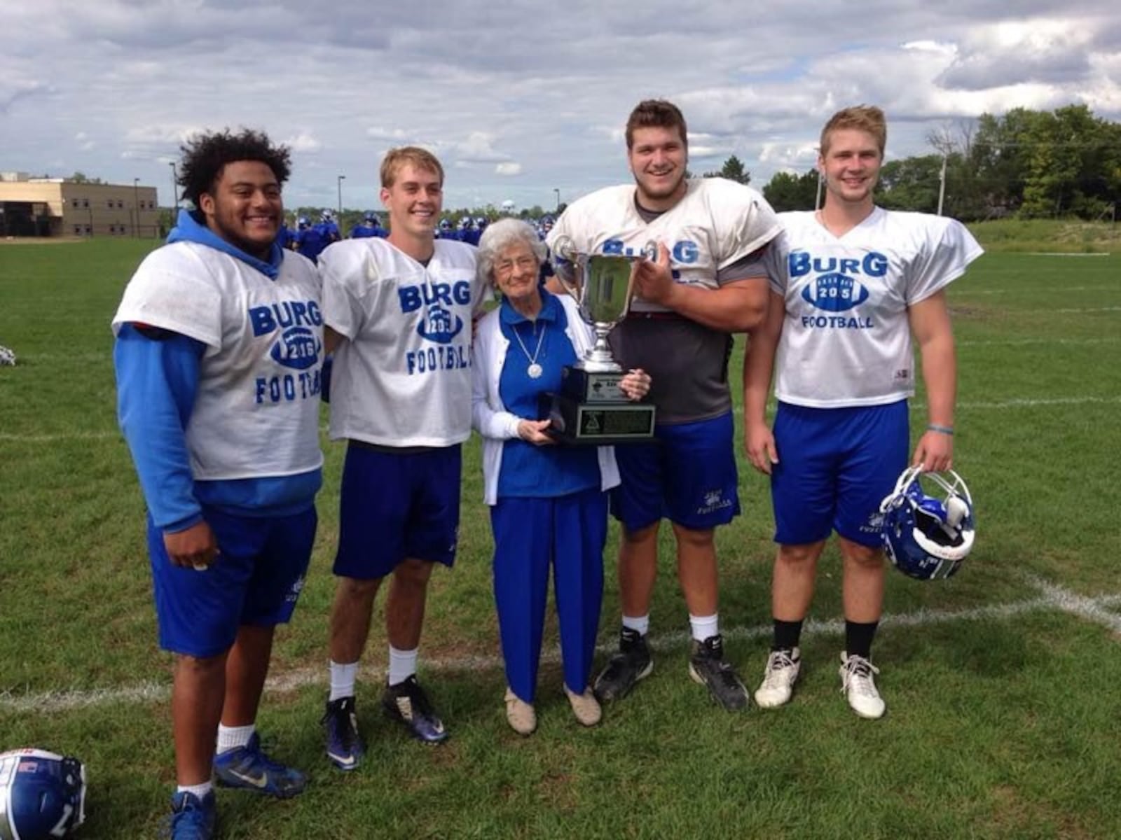 Virginia Kinderdine, the daughter in law of Hobby Kinderdine, was into her 90s when she presented Miamisburg High football players, including Josh Myers(second from right and now the center of the Green Bay Packers) the Partlow Kinderdine Cup, given to the winners of the game between next door rivals , Miamisburg High and West Carrollton High. (Contributed Photo)