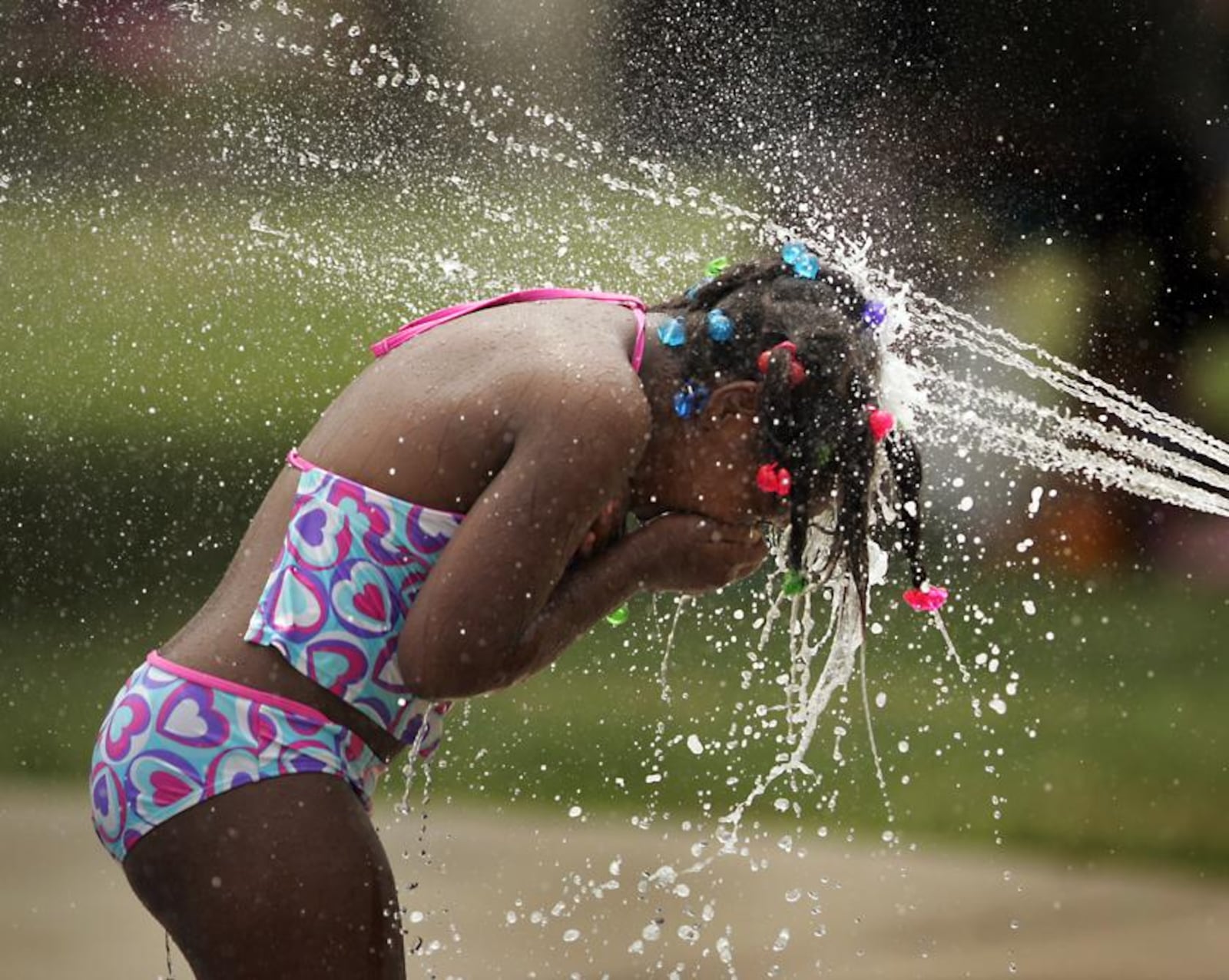 A girl plays in the cooling water jets of the spray at McIntosh Spray Park on Riverview Ave.