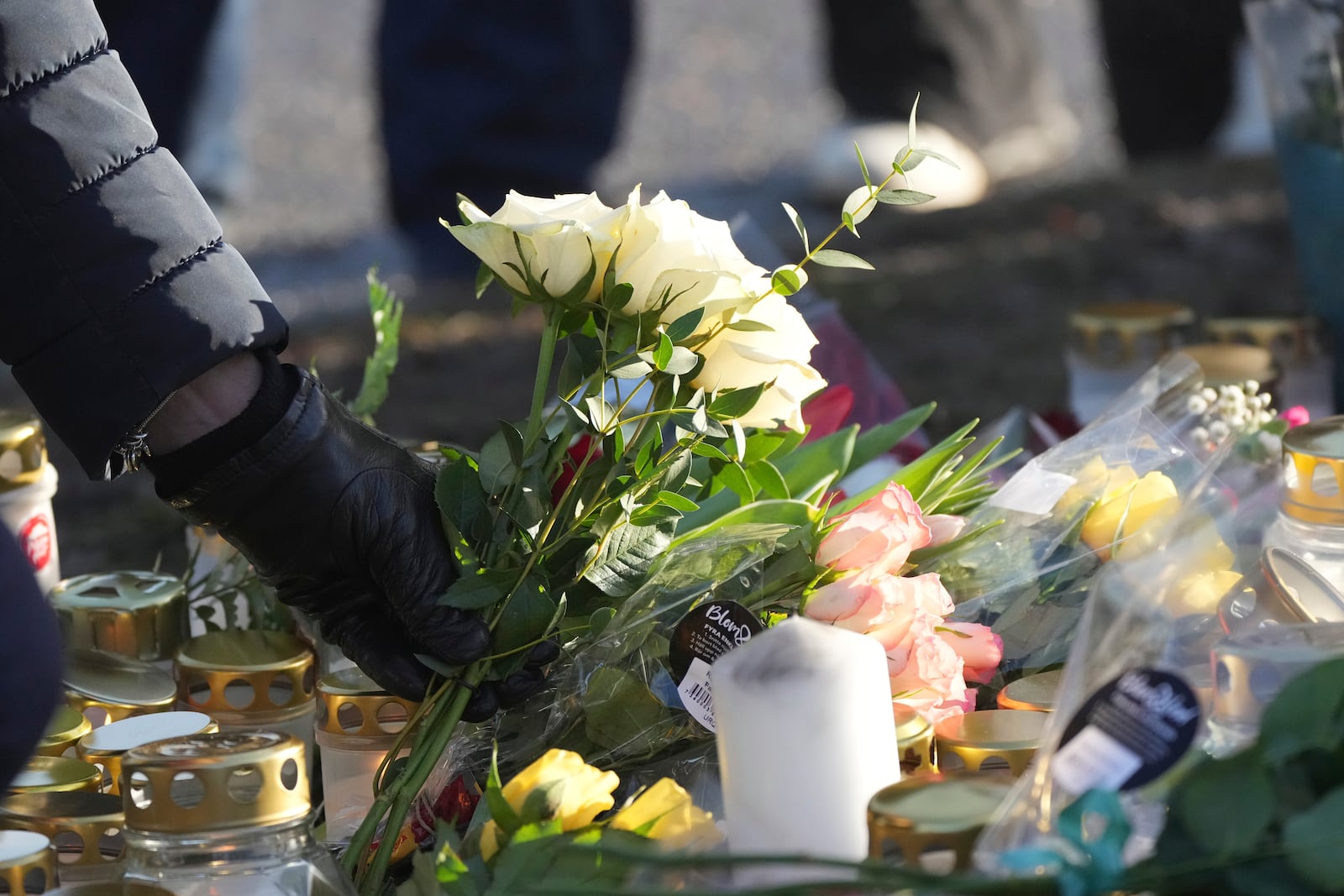 People gather at a makeshift memorial near the scene of a shooting on the outskirts of Orebro, Sweden, Wednesday, Feb. 5, 2025. (AP Photo/Sergei Grits)