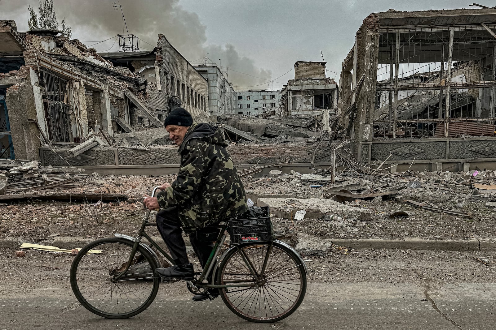 FILE - A man rides on a bike in front of the mail office which was destroyed by a Russian airstrike in Kurakhove, Donetsk region, Ukraine, on Nov. 7, 2024. (AP Photo/Anton Shtuka, File)