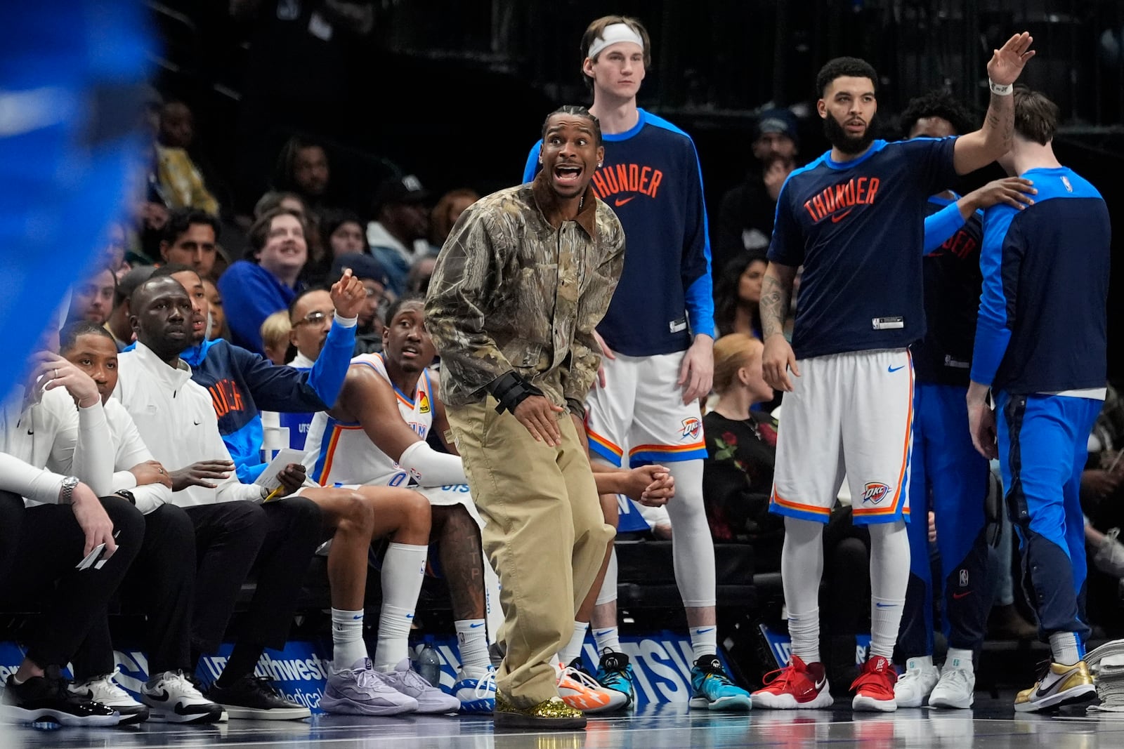 Injured Oklahoma City Thunder guard Shai Gilgeous-Alexander, center front, yells from the sideline during the second half of an NBA basketball game against the Dallas Mavericks, Friday, Jan. 17, 2025, in Dallas. (AP Photo/LM Otero)