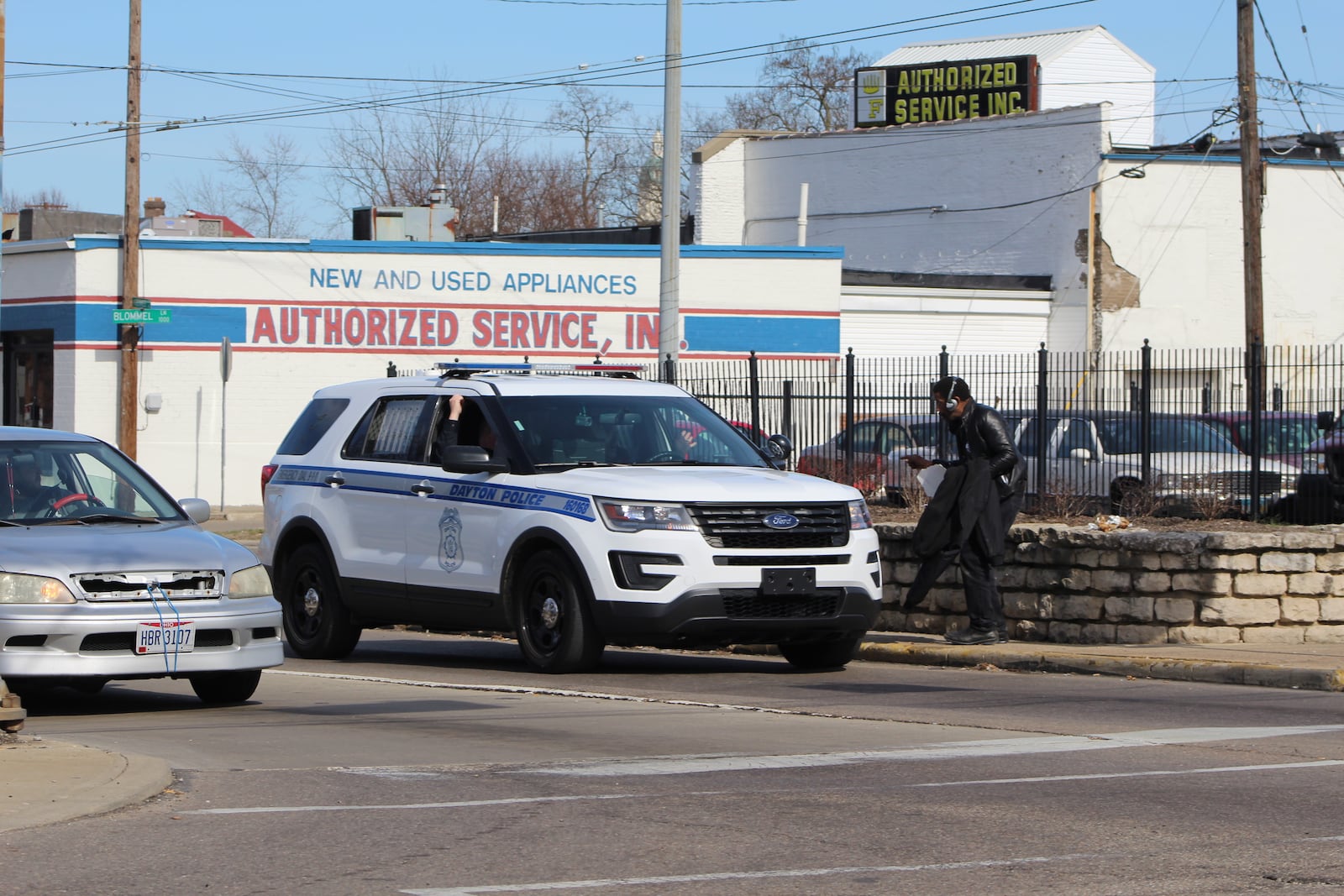 Dayton police officers talk to a panhandler at Wayne Avenue and South Keowee Street. CORNELIUS FROLIK / STAFF