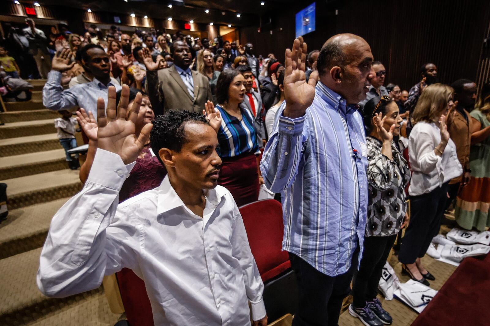 Berihu Gebrhet, left and Khaldd Alkurdi along with 85 other naturalization candidates raise their right hand and swear allegiance to the U.S. Constitution at the naturalization ceremony held at the Montgomery County Board of Election on Tuesday Sept. 20, 2022. JIM NOELKER/STAFF