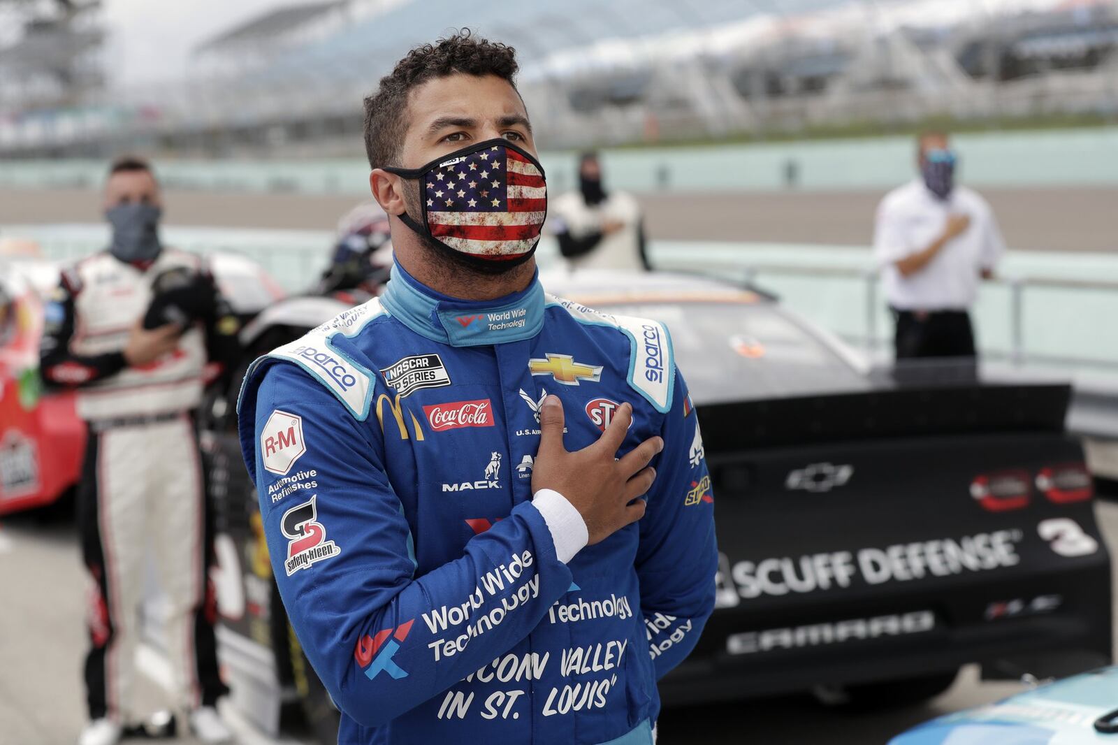 Bubba Wallace stands for the national anthem before a NASCAR Cup Series auto race Sunday, June 14, 2020, in Homestead, Fla. (AP Photo/Wilfredo Lee)