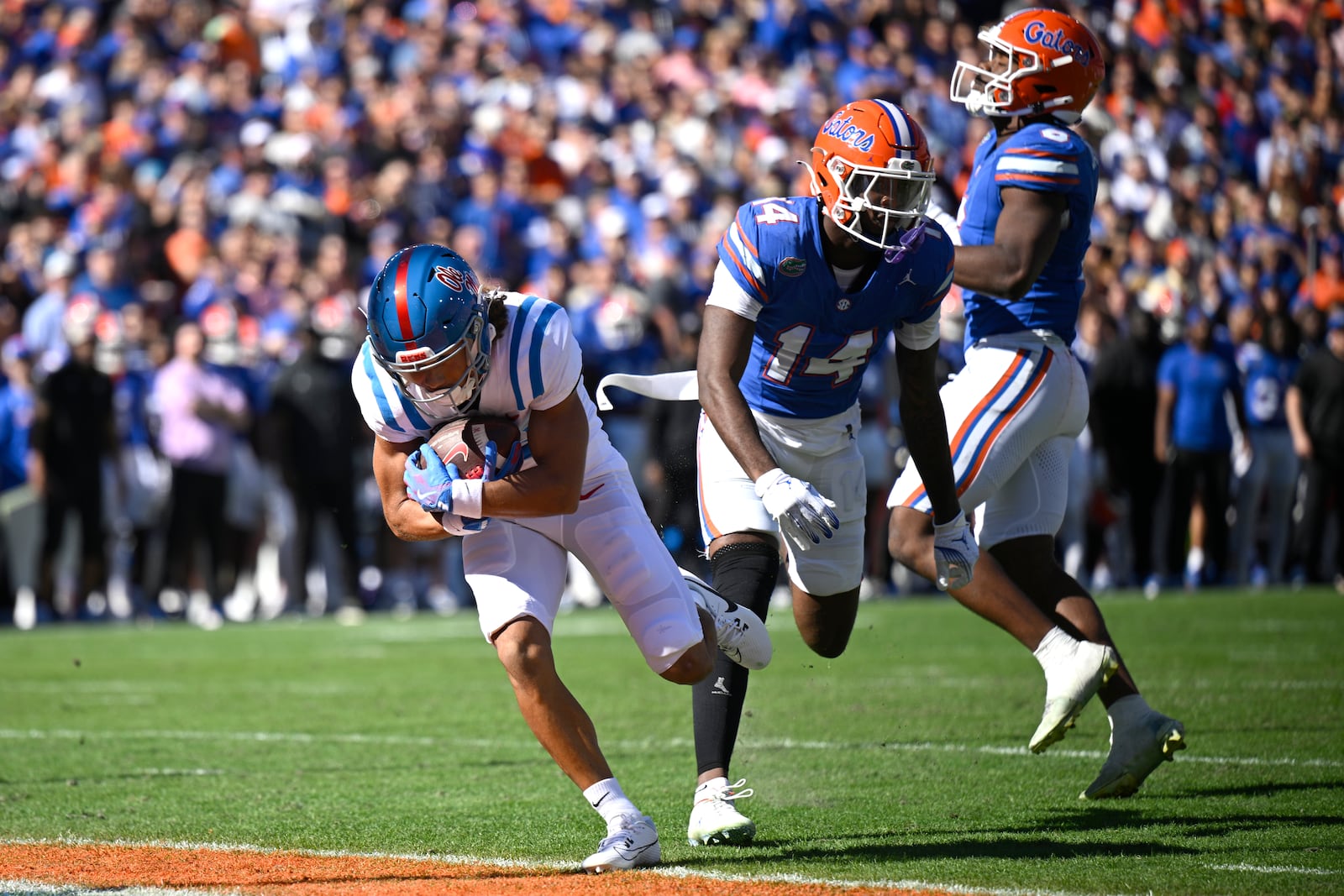 Mississippi wide receiver Cayden Lee, left, scores a touchdown in front of Florida defensive back Jordan Castell (14) on a 22-yard pass play during the first half of an NCAA college football game, Saturday, Nov. 23, 2024, in Gainesville, Fla. (AP Photo/Phelan M. Ebenhack)