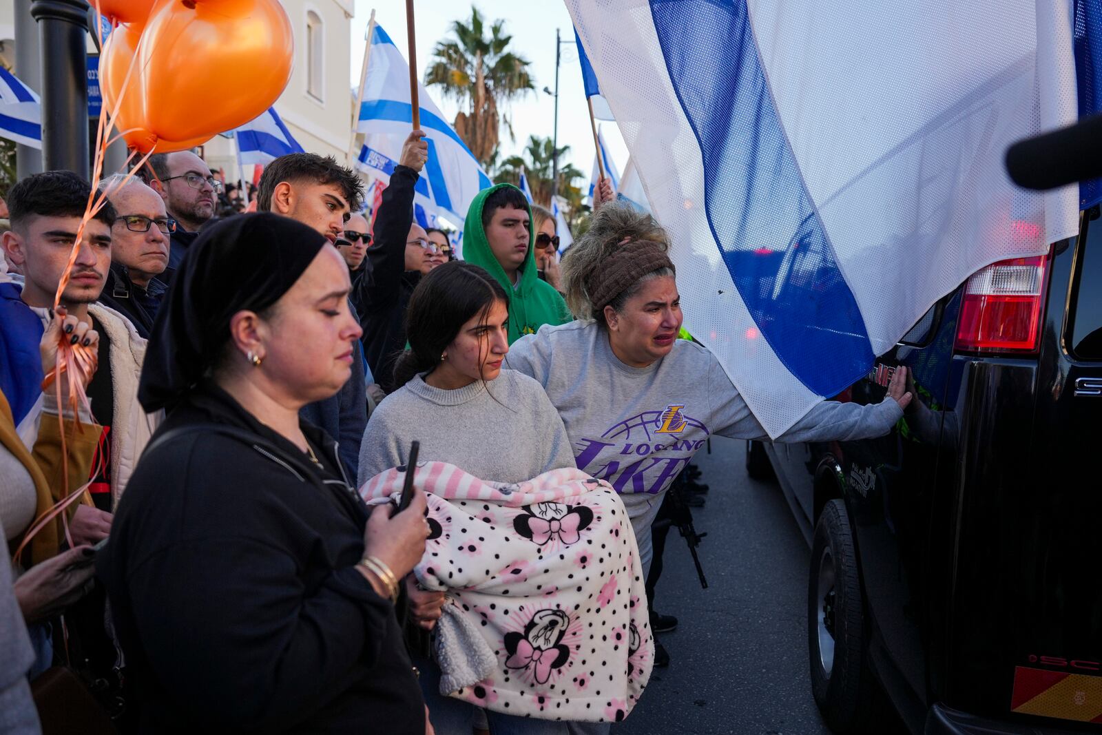 Mourners react as the convoy carrying the coffins of slain hostages Shiri Bibas and her two children, Ariel and Kfir, passes by during their funeral procession in Rishon Lezion, Israel, Wednesday, Feb. 26, 2025. The mother and her two children were abducted by Hamas on Oct. 7, 2023, and their remains were returned from Gaza to Israel last week as part of a ceasefire agreement with Hamas. (AP Photo/Ariel Schalit)