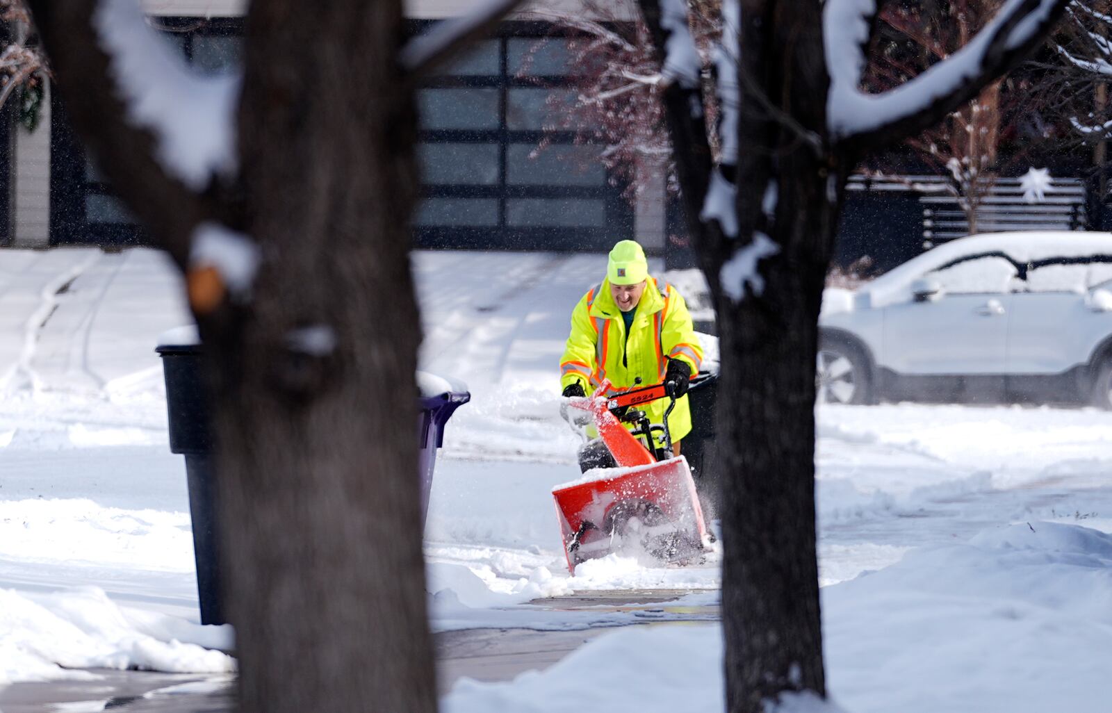 A man uses a snowblower to clear a sidewalk as a winter storm sweeps over the intermountain West and across the country Tuesday, Jan. 7, 2025, in Denver. (AP Photo/David Zalubowski)