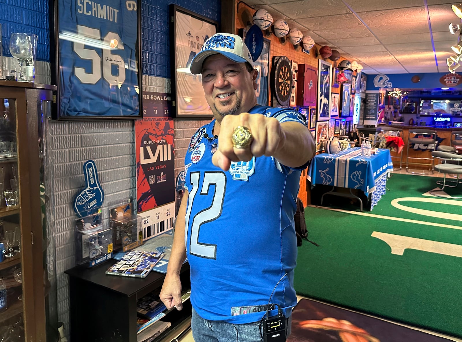 Detroit Lions fan Rob Gonzales displays a replica 1957 NFL football championship ring while standing in the basement of his home Thursday, Jan. 16, 2025, in Frenchtown Township, Mich. (AP Photo/Mike Householder)