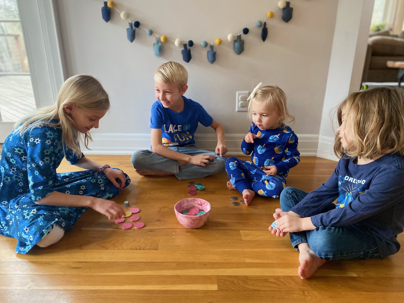 Stella, Avi, Mayim and Aaro Atkin play dreidel. CONTRIBUTED 