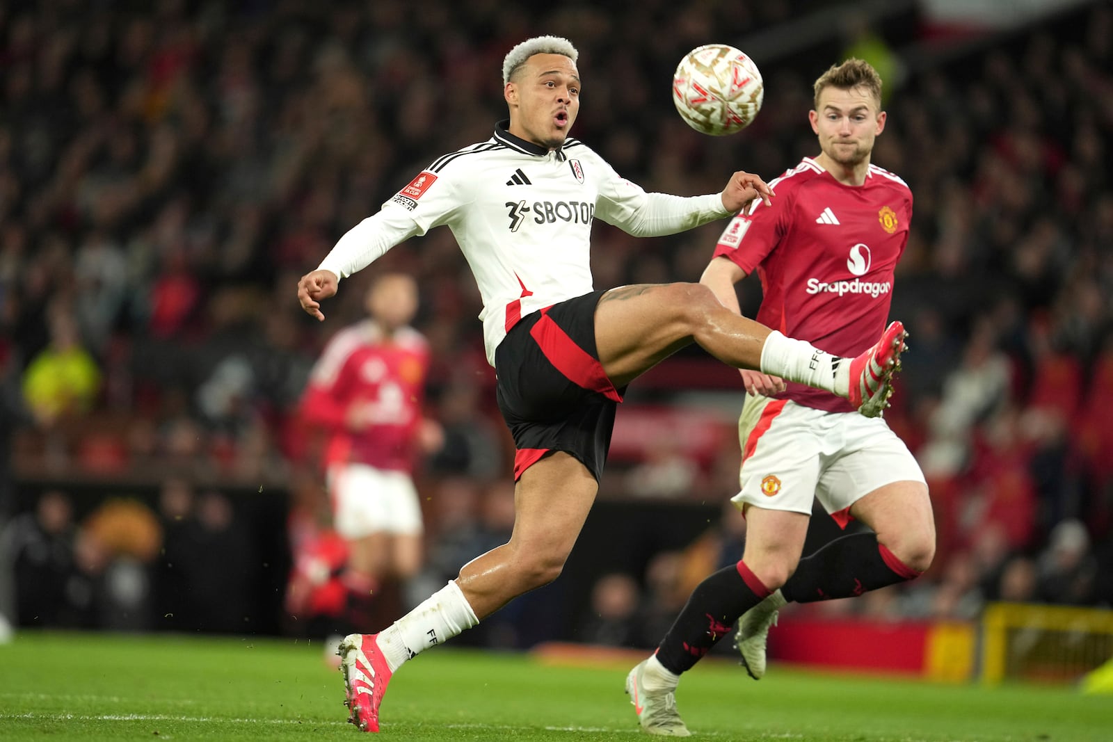 Fulham's Rodrigo Muniz, left, challenges for the ball with Manchester United's Matthijs de Ligt during the English FA Cup soccer match between Manchester United and Fulham at the Old Trafford stadium in Manchester, England, Sunday, March 2, 2025. (AP Photo/Jon Super)