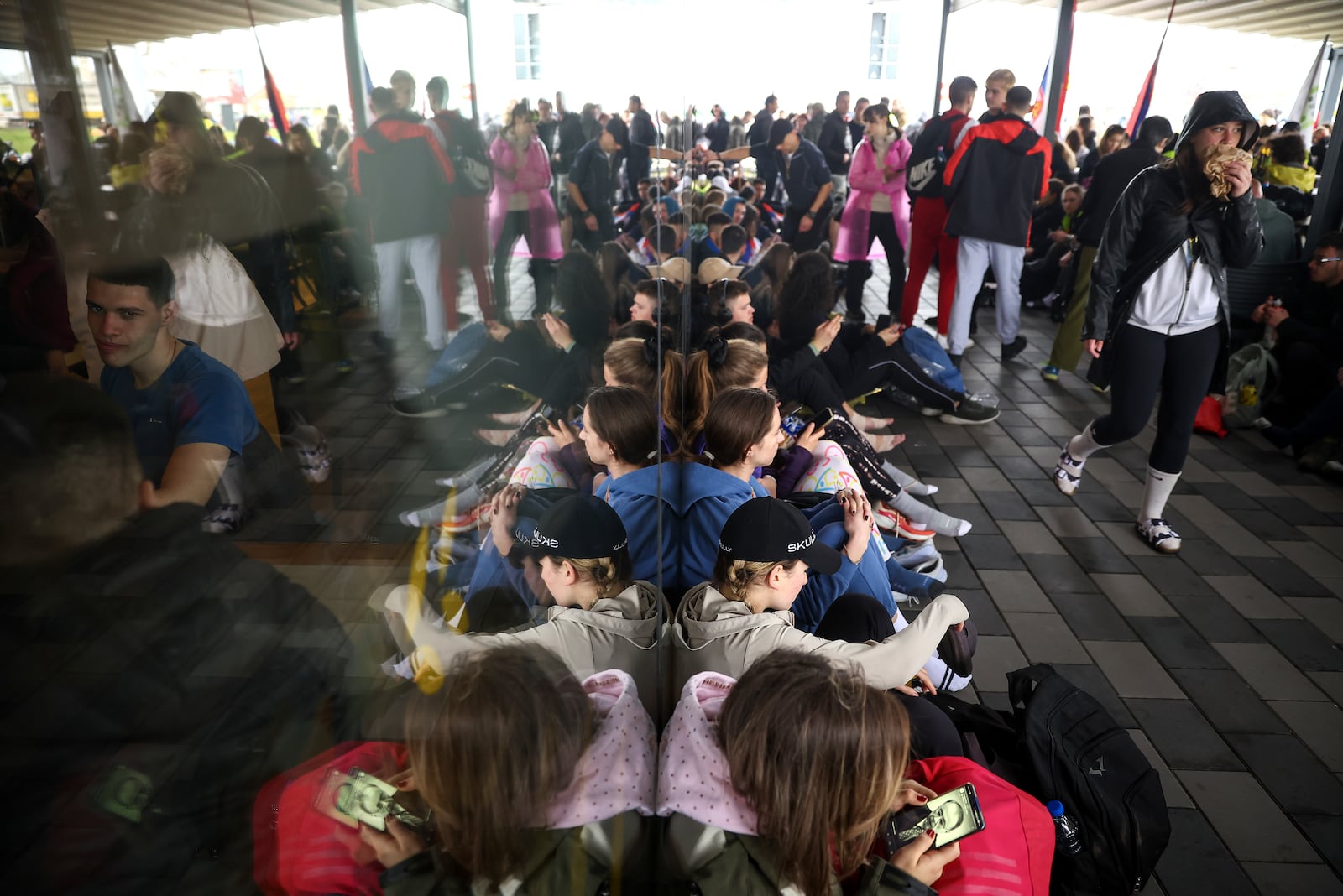 Students marching to Belgrade for a joint protest, shelter from the rain in front of a store as they take a break in Nova Pazova, Serbia, Friday, March 14, 2025. (AP Photo/Armin Durgut)