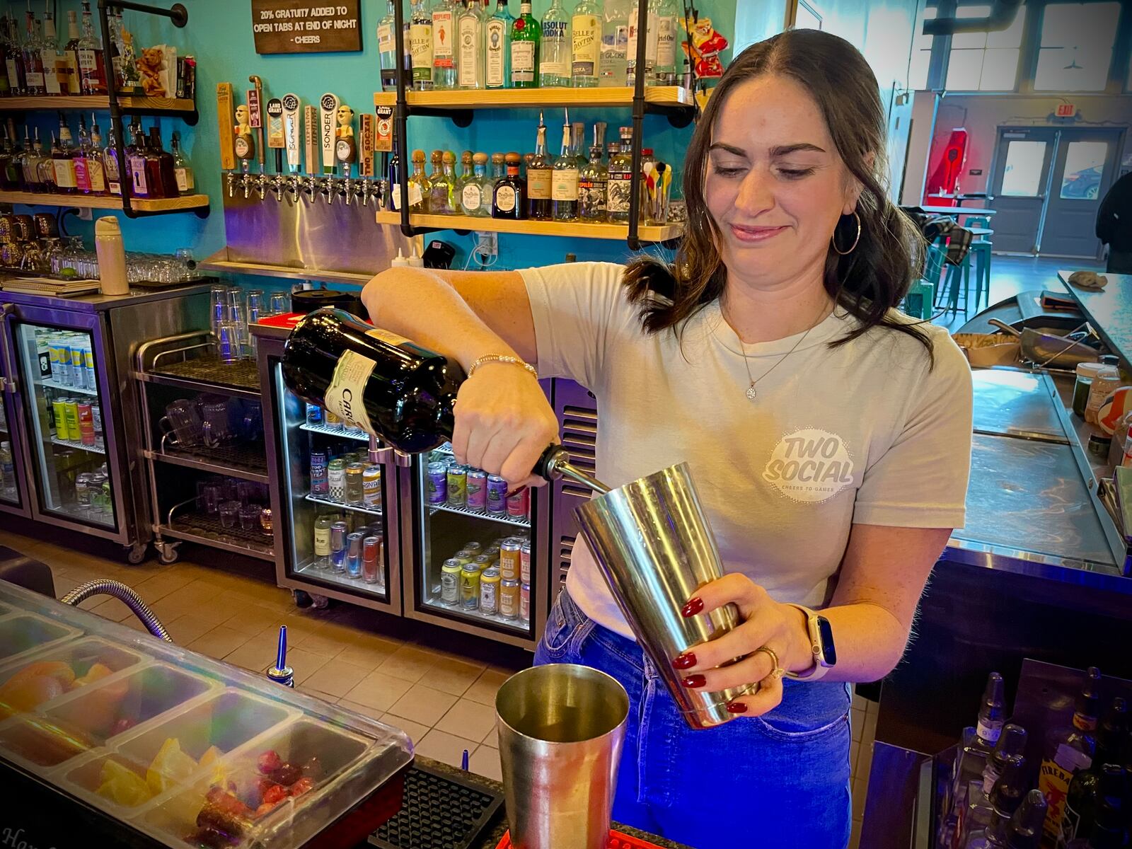 Two Social, located at 123 E. Third St. in Dayton, has eight holiday-themed cocktails on its menu. Pictured is owner Kelsey Omlor making a drink. NATALIE JONES/STAFF