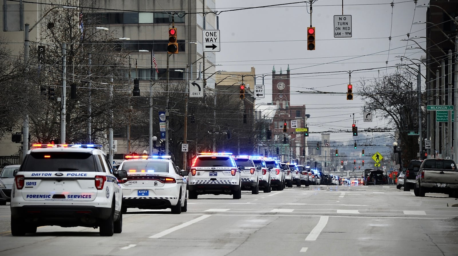 The processional for a Dayton police officer who died of cancer travels down Third Street by the safety building on February 24, 2022. MARSHALL GORBY \STAFF