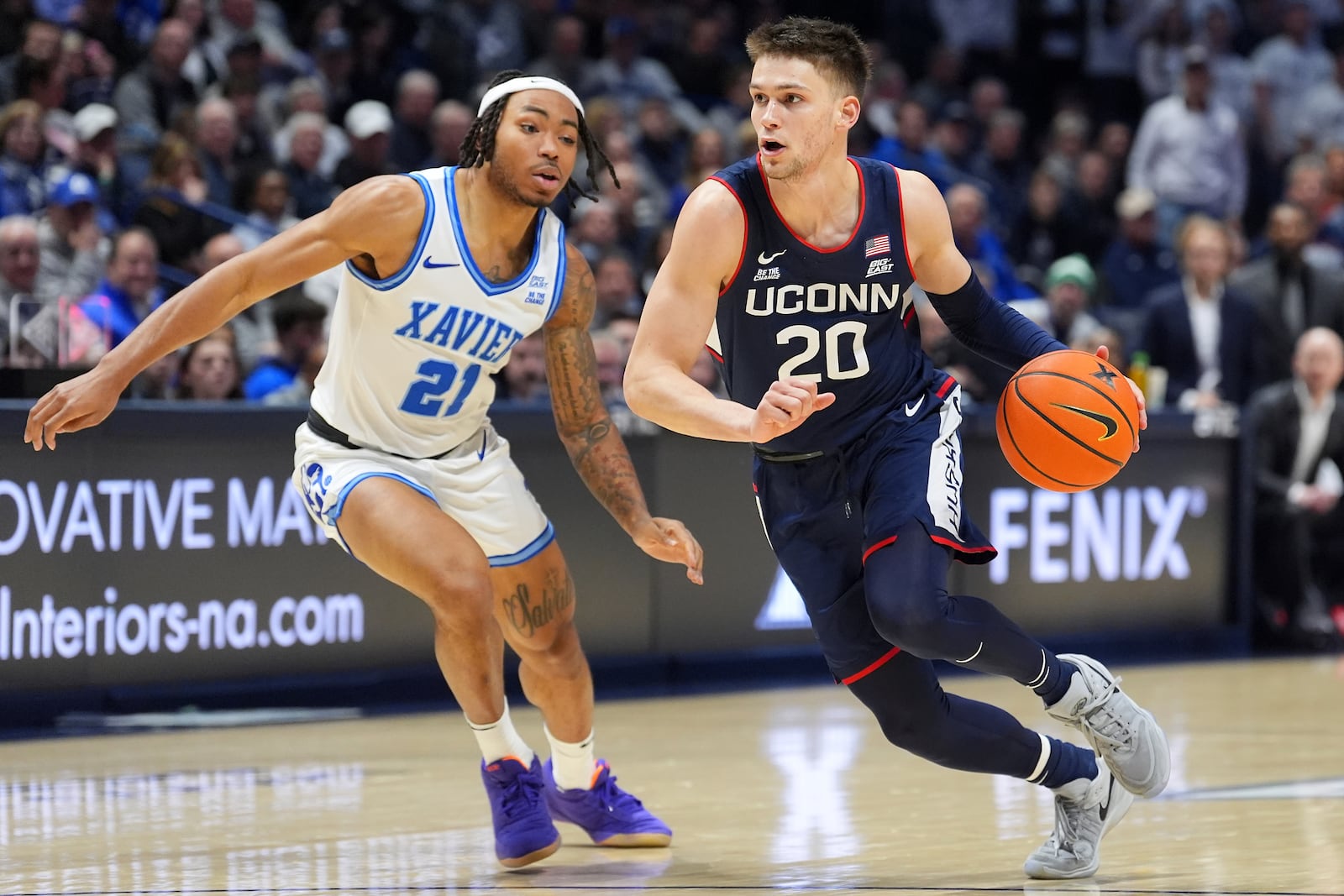 UConn's Aidan Mahaney, right, drives to the basket as Xavier's Dante Maddox Jr. defends during the first half of an NCAA college basketball game, Saturday, Jan. 25, 2025, Cincinnati. (AP Photo/Kareem Elgazzar)