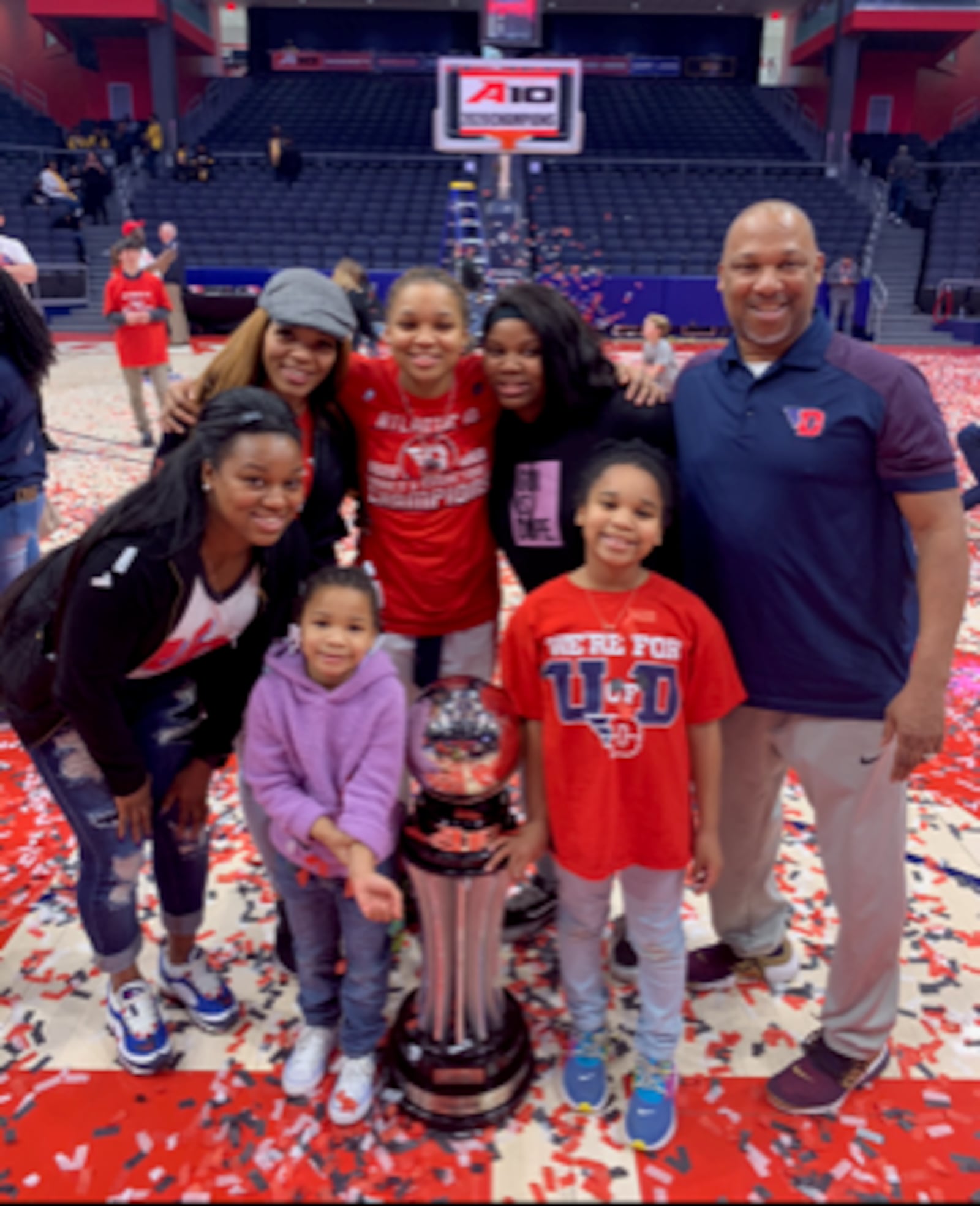 The Bradshaw Family at UD Arena after Flyers women won A-10 Tournament in March of 2020: (in front) Adrienne (age 5, in purple) and Aubrie (age 8, in red); (Back Row, left to right) Amari (leaning over) mom Kelley, Araion, Ariel and dad Eric.. CONTRIBUTED