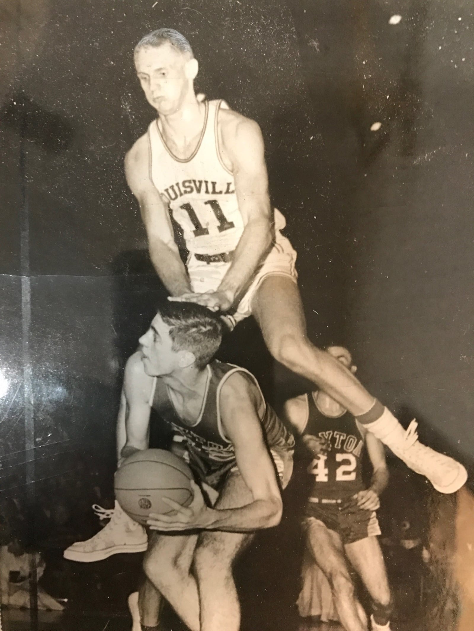 Dayton Flyers forward Pat Allen gives a fake that sends Louisville’s 6-foot-11 center Fred Sawyer airborne. CONTRIBUTED