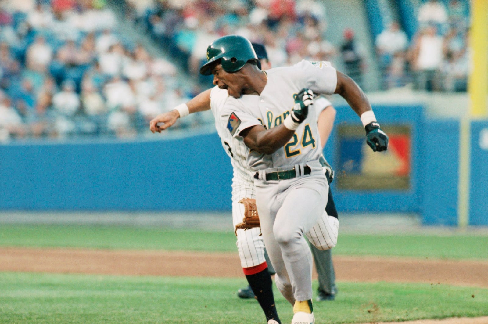 FILE - Oakland Athletics Rickey Henderson (24) keeps just ahead of Chicago White Sox shortstop Ozzie Guillen during a rundown between first and second base during the third inning of a baseball game June 14, 1994, in Chicago. (AP Photo/Fred Jewell, File)