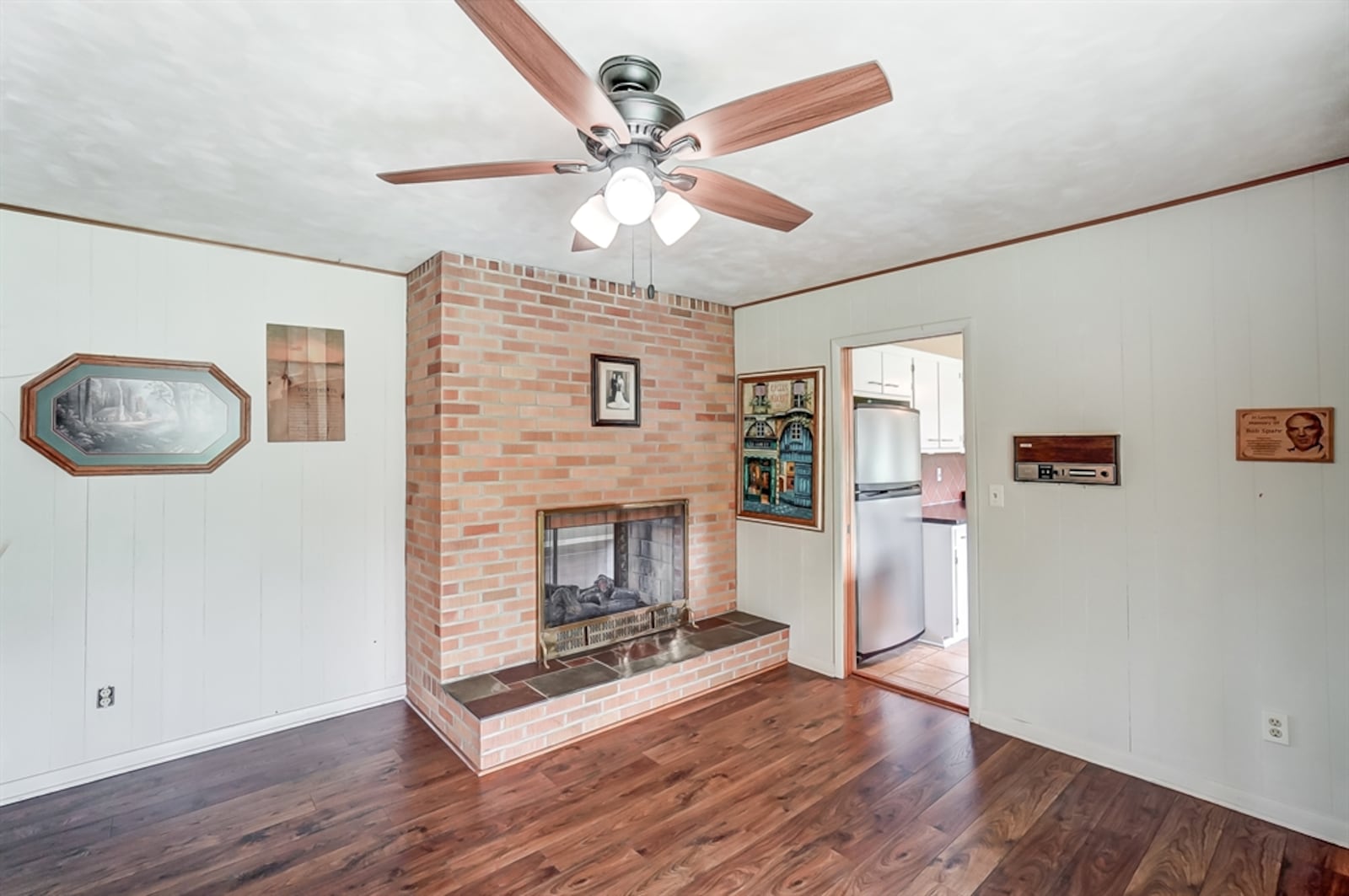 The stone-brick fireplace has a raised stone hearth and glass doors.