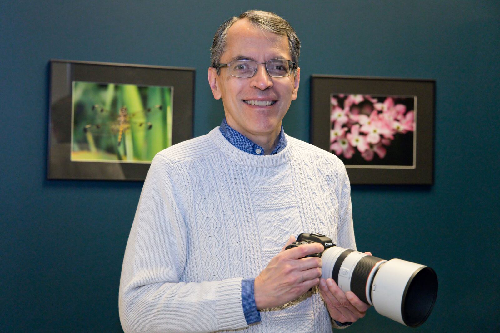 Adam Alonzo is seen with his camera and framed nature prints. CONTRIBUTED