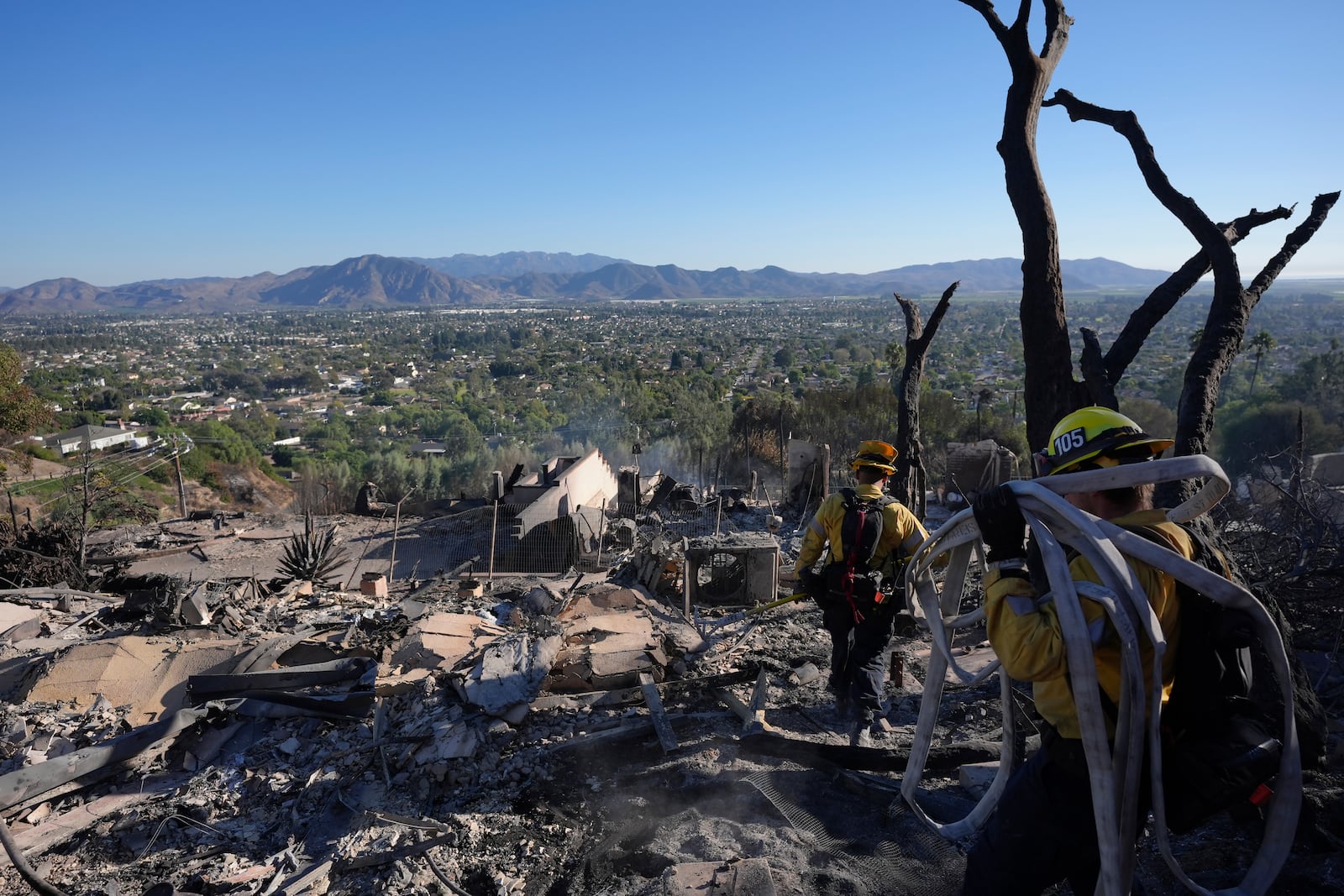 Los Angeles Fire Department firefighters work at a home destroyed by the Mountain Fire in Camarillo, Calif., Friday, Nov. 8, 2024. (AP Photo/Jae C. Hong)