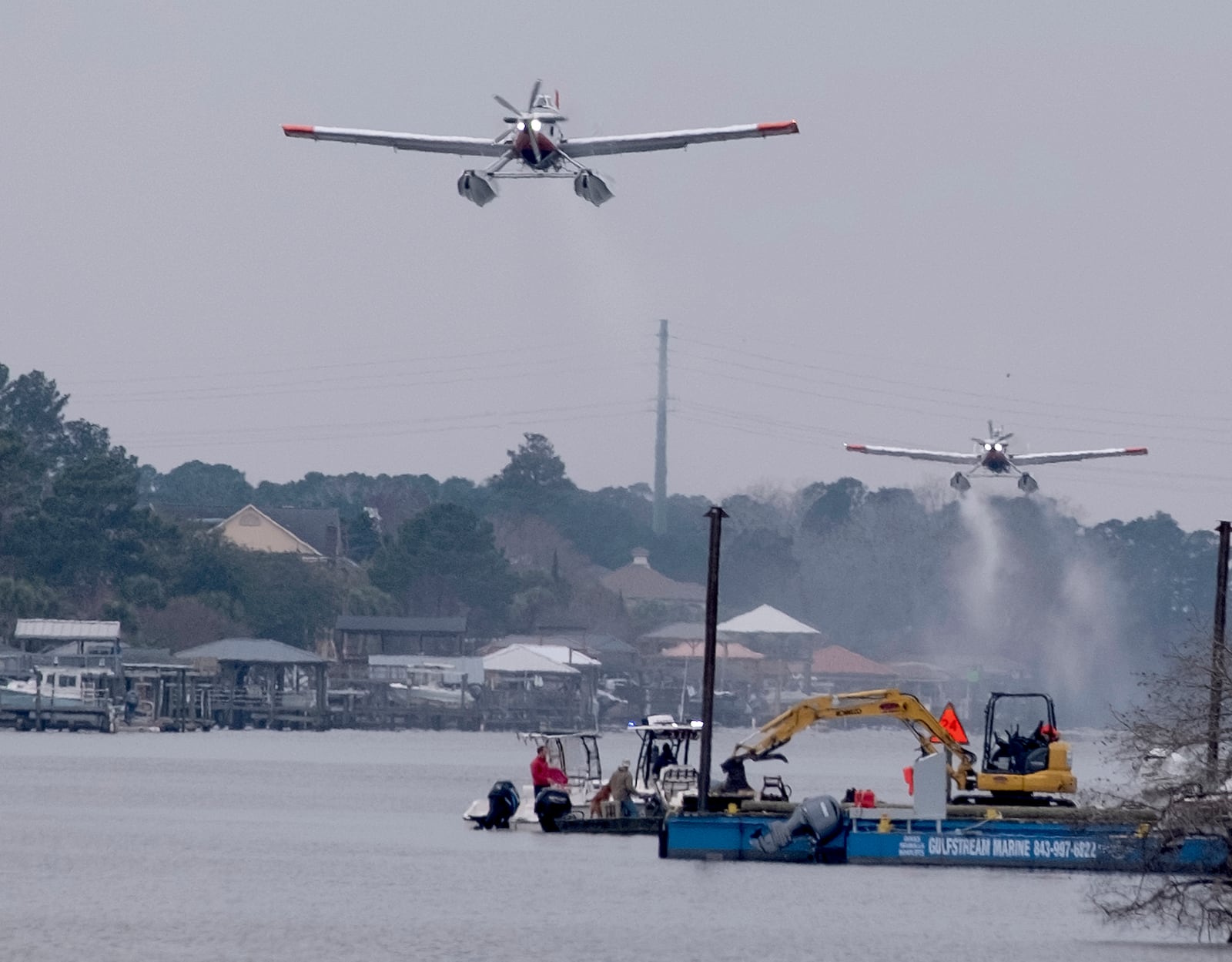 Planes fill bladders with water from the Intracoastal Waterway and empty the water on hot spots in the Carolina Forest wildfire Sunday, March 2, 2025, in Myrtle Beach, S.C. (Janet Morgan/The Post And Courier via AP)