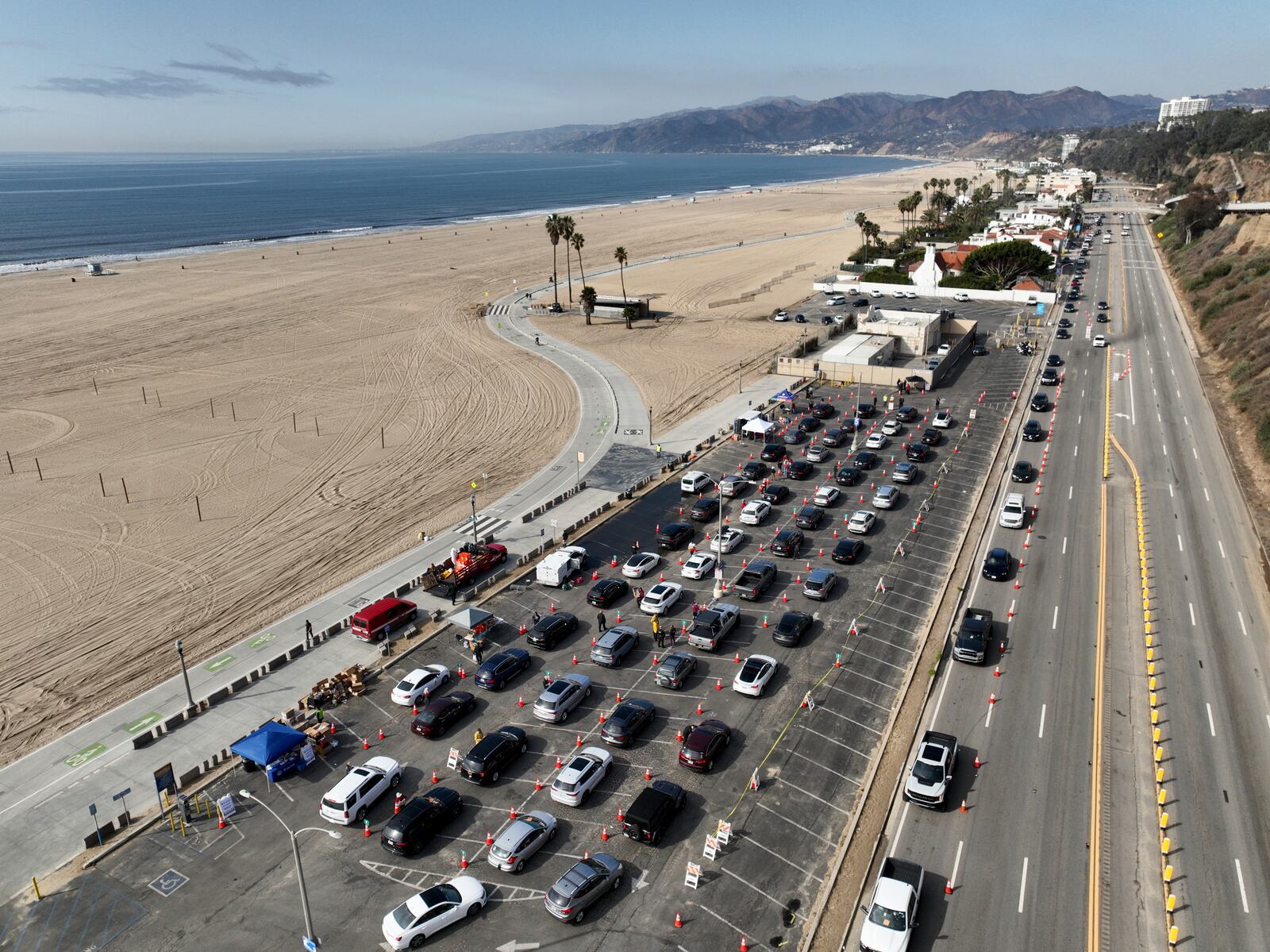 Motorists form a queue in a parking lot and along Pacific Coast Highway waiting to enter the Palisades Fire zone Tuesday, Jan. 28, 2025 in Santa Monica, Calif. (AP Photo/Jae C. Hong)