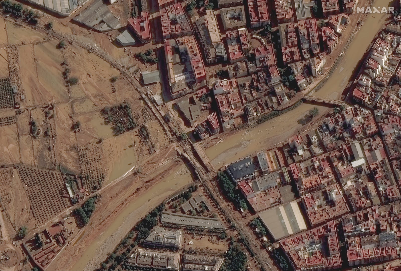 This satellite image released by Maxar Technologies shows mud and flooded fields and a damaged road and bridge caused by floods in Valencia, Spain, Thursday Oct. 31, 2024. (Satellite image ©2024 Maxar Technologies via AP)