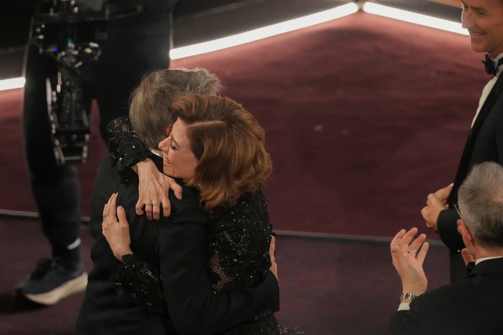 Fernanda Torres, right, embraces Walter Salles after he wins the award for "I'm Still Here" from Brazil, for best international feature film during the Oscars on Sunday, March 2, 2025, at the Dolby Theatre in Los Angeles. (AP Photo/Chris Pizzello)