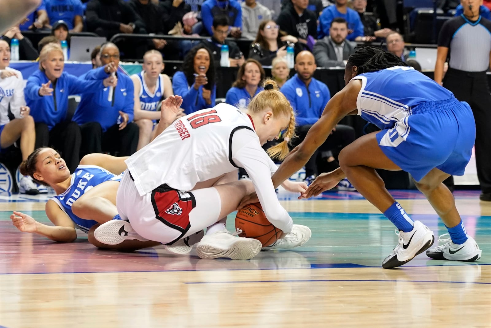 NC State forward Tilda Trygger, center, battles Duke guard Jadyn Donovan, right, and Duke forward Delaney Thomas, left, for a loose ball during an NCAA college basketball game in the championship of the Atlantic Coast Conference tournament Greensboro, N.C., Sunday, March 9, 2025. (AP Photo/Chuck Burton)