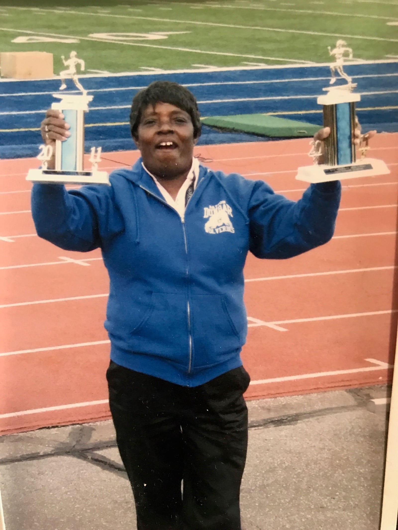 Anna Earley – one of the most successful high school coaches in Dayton history during her 50 years in the DPS system, holds the Dayton City League championship trophies her girls and boys track teams at Dunbar won in the early 1990s. On Friday her daughter Alicia – who she calls Poochie -- will be enshrined on the Dunbar Wall of Fame. CONTRIBUTED