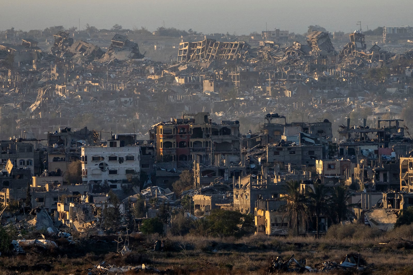 Destroyed buildings stand inside the Gaza Strip, as seen from southern Israel, Tuesday, Jan. 7, 2025. (AP Photo/Ariel Schalit)