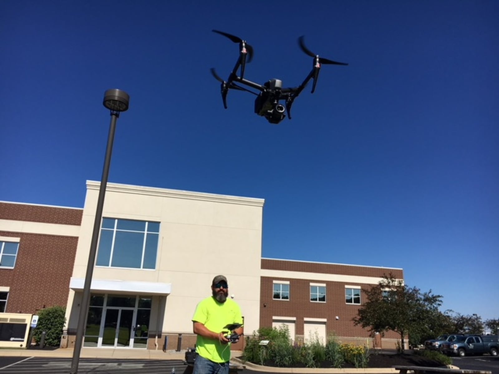 Aaron Lawrence, team leader for Woolpert’s unmanned systems efforts, sends a drone aloft behind the engineering company’s Idea Center Boulevard offices in Beavercreek. THOMAS GNAU/STAFF