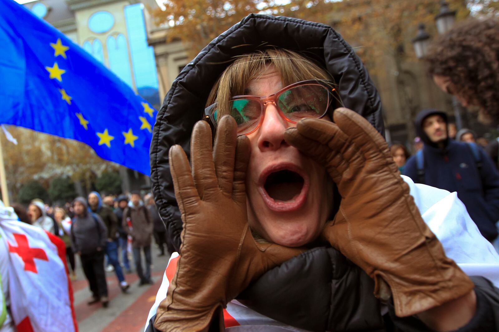 A protester shouts during a rally to demand new parliamentary elections in the country, near the Parliament's building in Tbilisi, Georgia, on Monday, Nov. 25, 2024. (AP Photo/Shakh Aivazov)