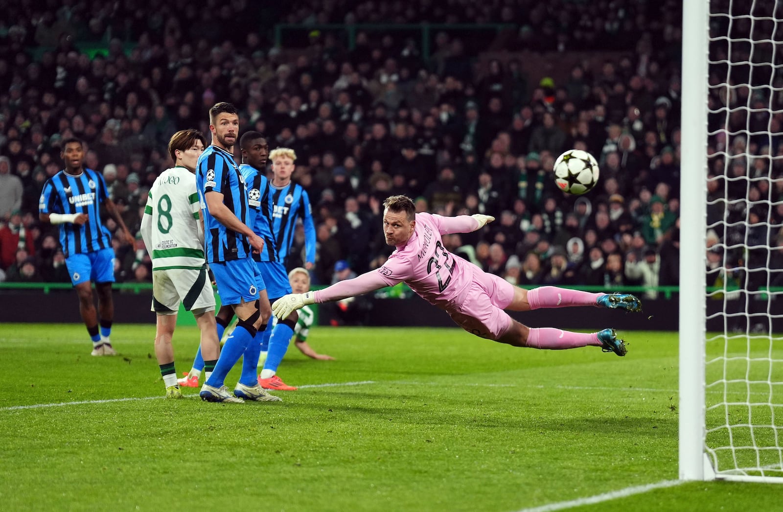 Celtic's Daizen Maeda scores past Club Brugge goalkeeper Simon Mignolet during the UEFA Champions League opening phase soccer stage match at Celtic Park, Glasgow, Scotland, Wednesday Nov. 27, 2024. (Andrew Milligan/PA via AP)