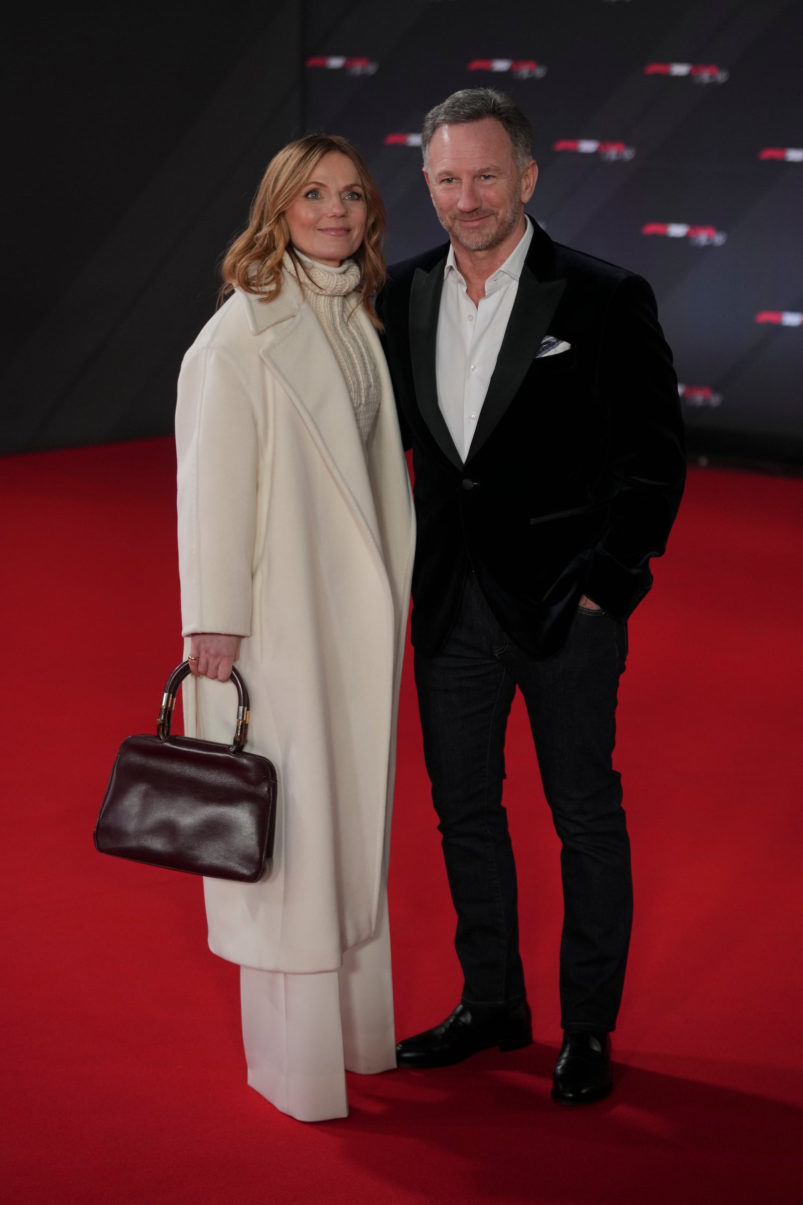 Red Bull team principal Christian Horner and his wife Geri Halliwell pose for cameras as they arrive to the F1@75 launch event at the O2 arena in London, Tuesday, Feb. 18, 2025. (AP Photo/Kin Cheung)