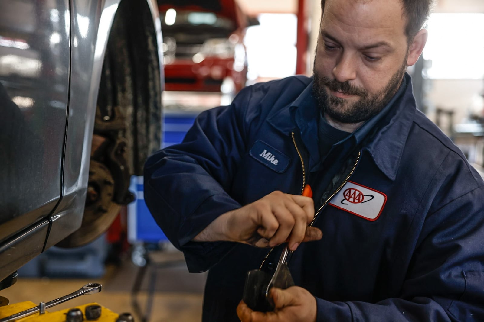 AAA auto mechanic Michael Mollett replaces brakes at the service center in Beavercreek Thursday, March 28, 2024. Auto repair is a good industry for workers to be in right now, said Dan Scroggins, vice president of personal lines insurance at AAA. Wages are up significantly over the last three years, and there is a ton of work, Scroggins said.  JIM NOELKER/STAFF