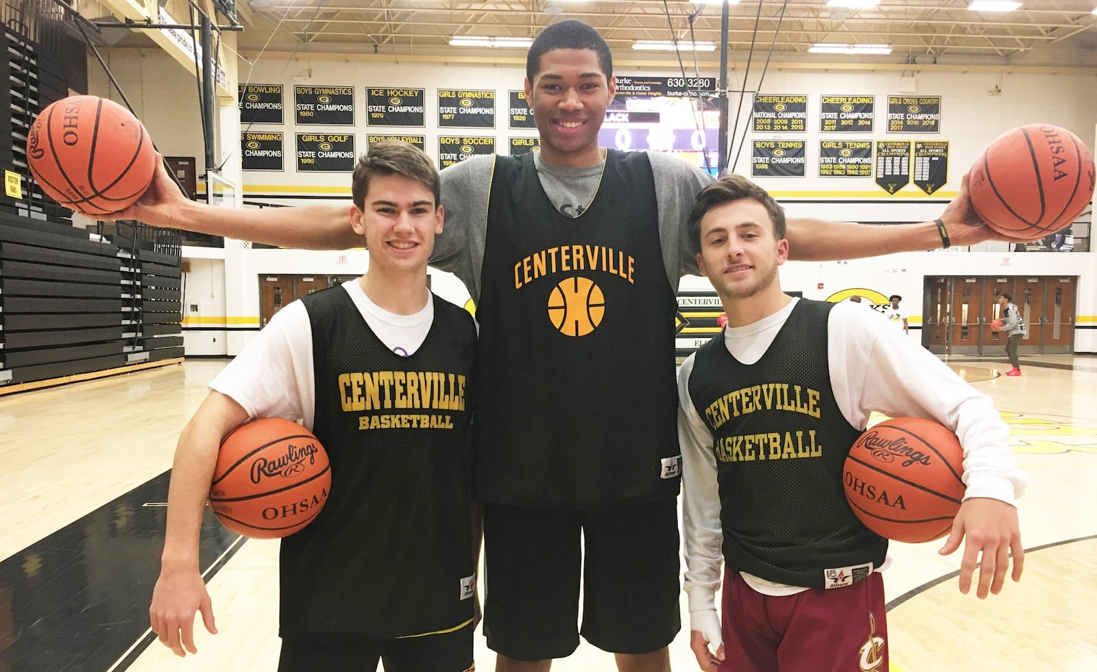 Centerville High School 6-9 junior Mo Njie towers over starting guards Matt Pearce (left) and Ryan Marchal prior to a preseason practice on Wednesday, Nov. 28, 2018. MARC PENDLETON / STAFF